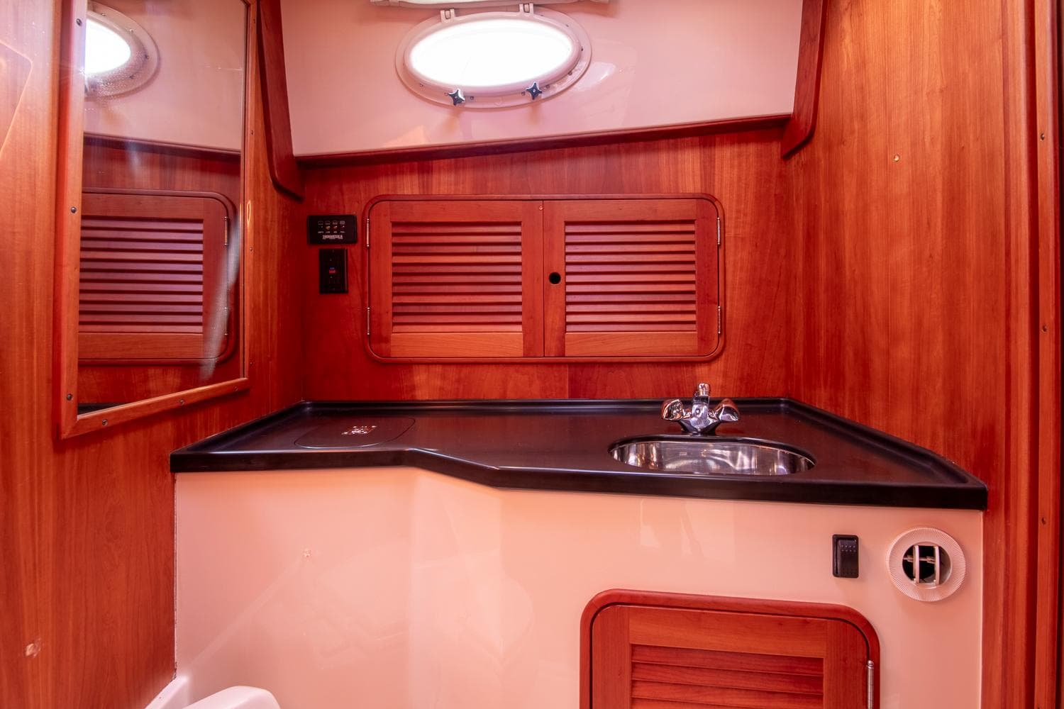 2006 Hinckley Talaria 44 FB yacht bathroom with wood paneling and sink.