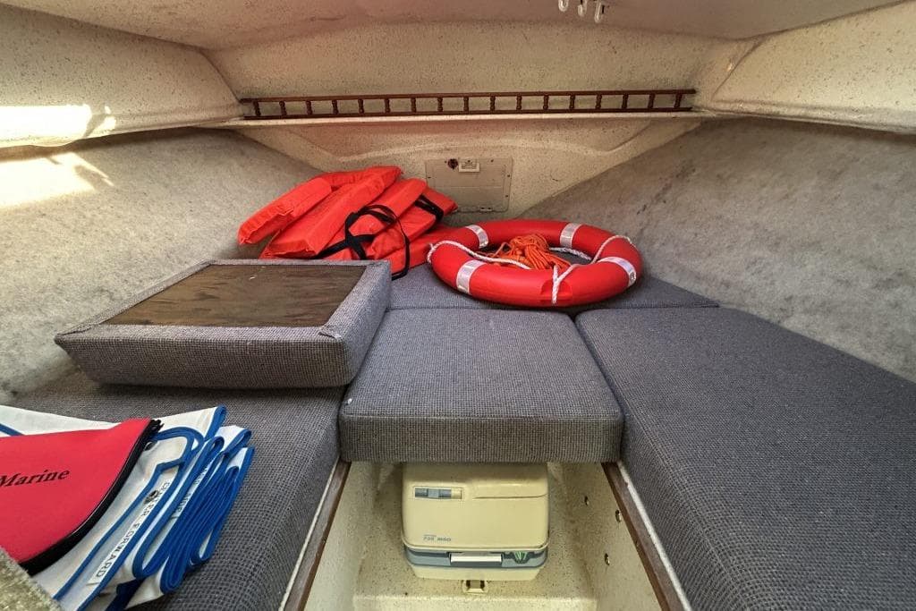 Interior of a 1992 SeaSport 2200 Sportsman boat with safety gear and cushions.