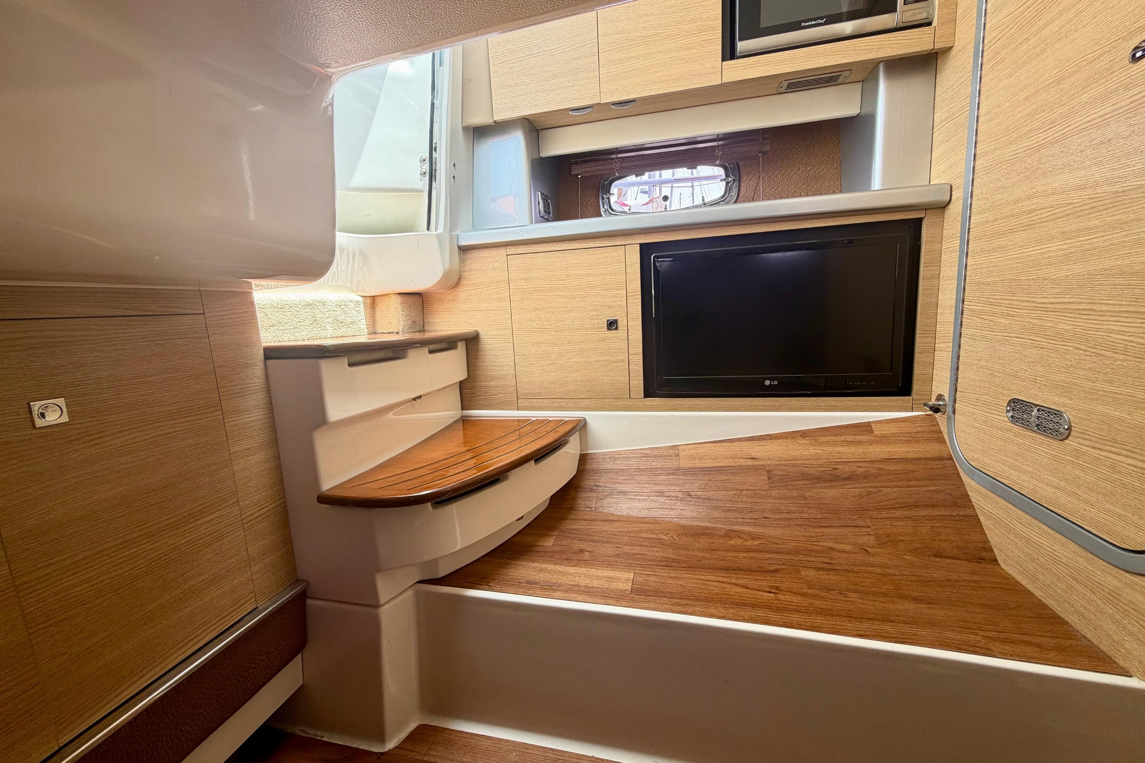 Interior of 2014 Chaparral 327 SSX boat with wood flooring and modern amenities.