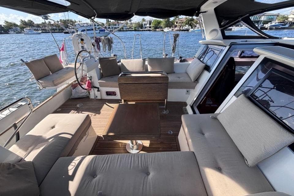 Spacious deck of 2015 Beneteau Sense 55 yacht with comfortable seating and scenic water view.