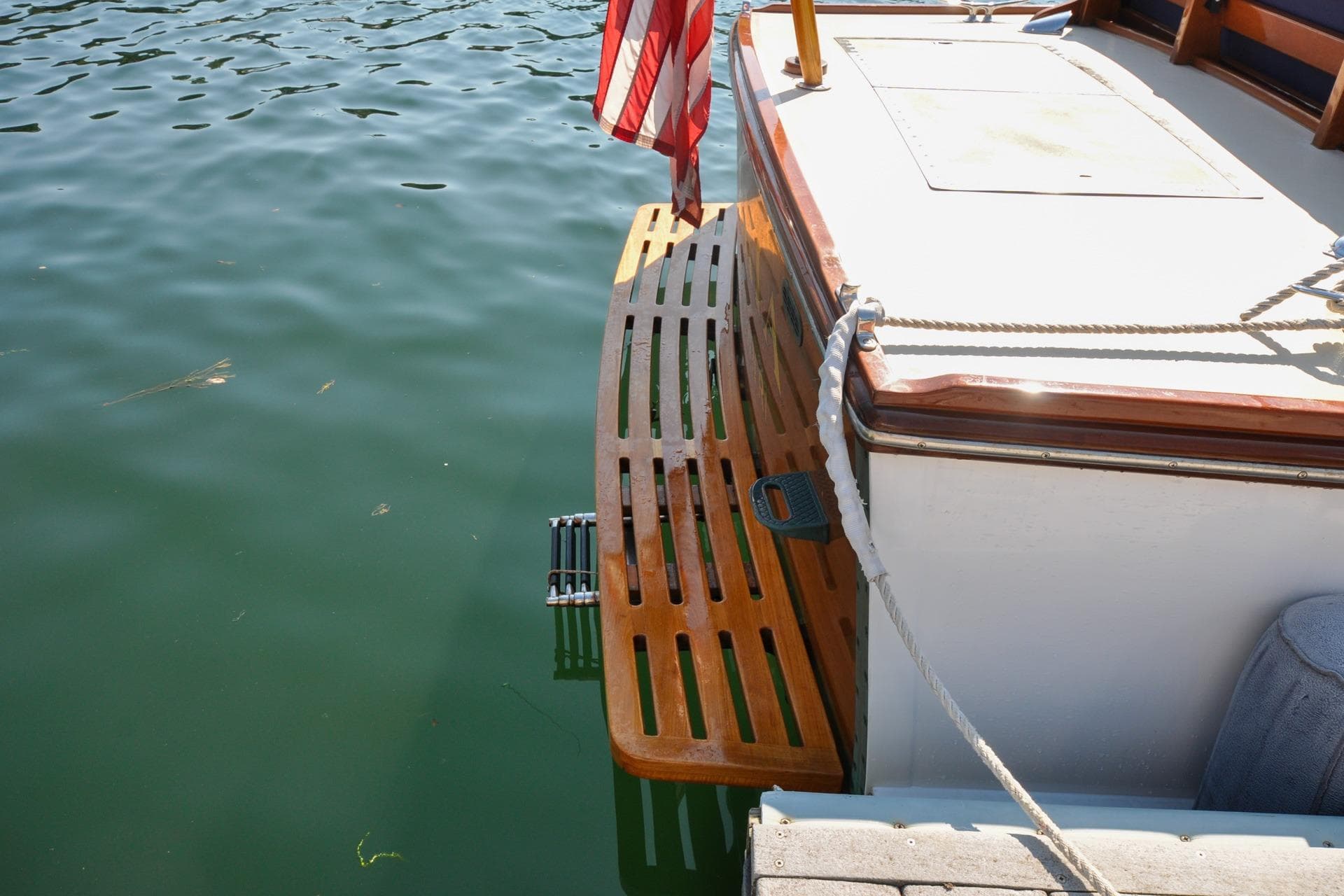 Vintage 1958 Bunker and Ellis 42 boat with wooden swim platform and American flag.