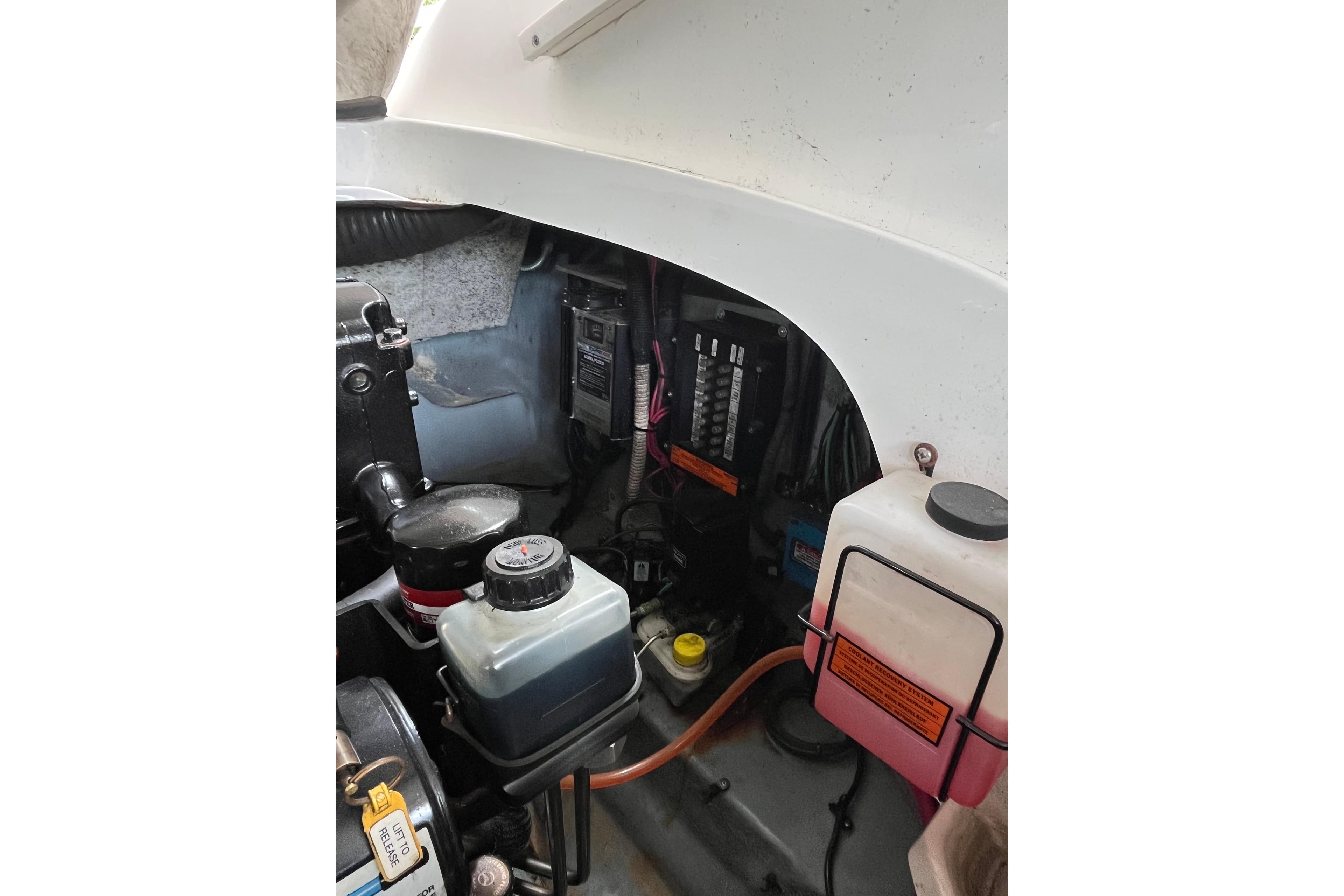 Engine compartment of a 2003 Sea Ray 290 Sun Sport boat, showing fluid reservoirs and components.