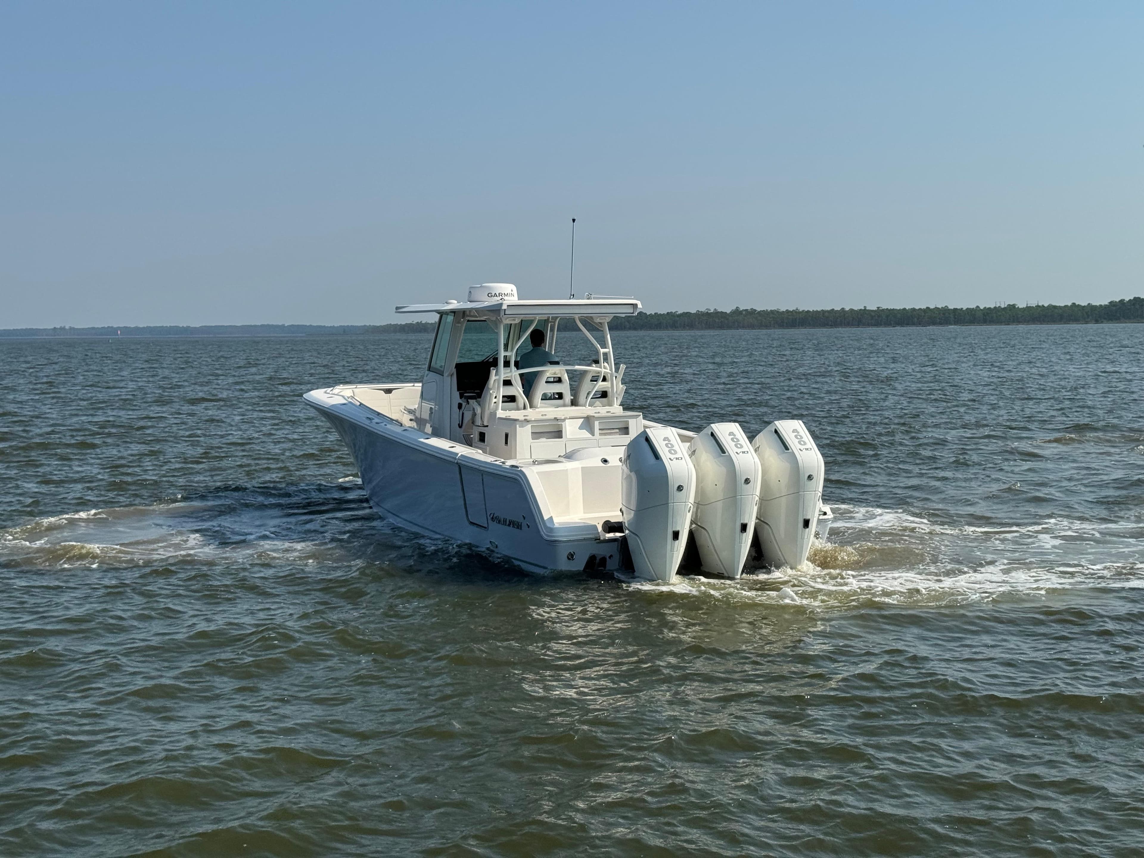 2024 Sailfish 360 CC boat cruising on open water with triple engines.