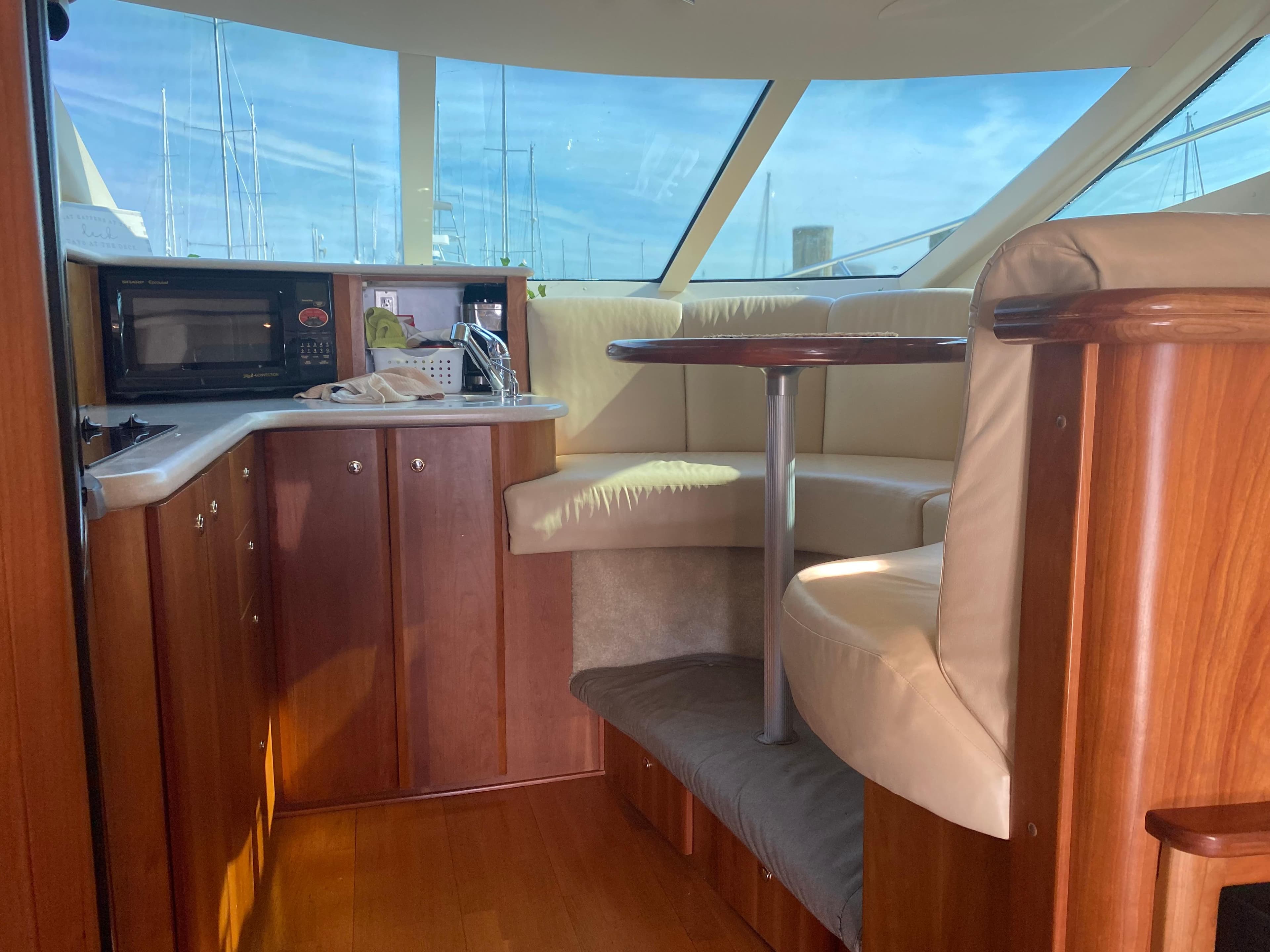 Interior of 2003 Silverton 410 Sport Bridge yacht with wood cabinetry and seating area.
