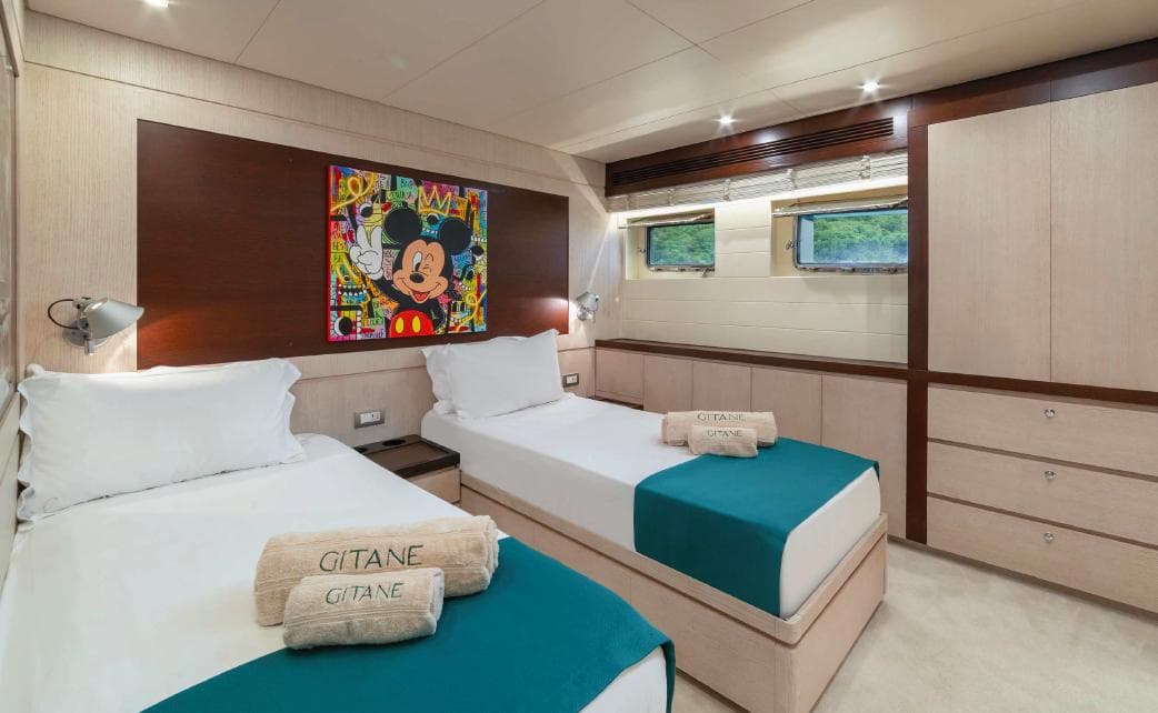 Luxurious Evadne 37mt yacht cabin with twin beds, vibrant artwork, and elegant decor, 2008 model.