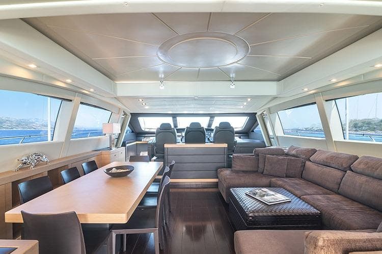 Luxurious interior of 2010 Mangusta 92 yacht with modern seating and dining area.
