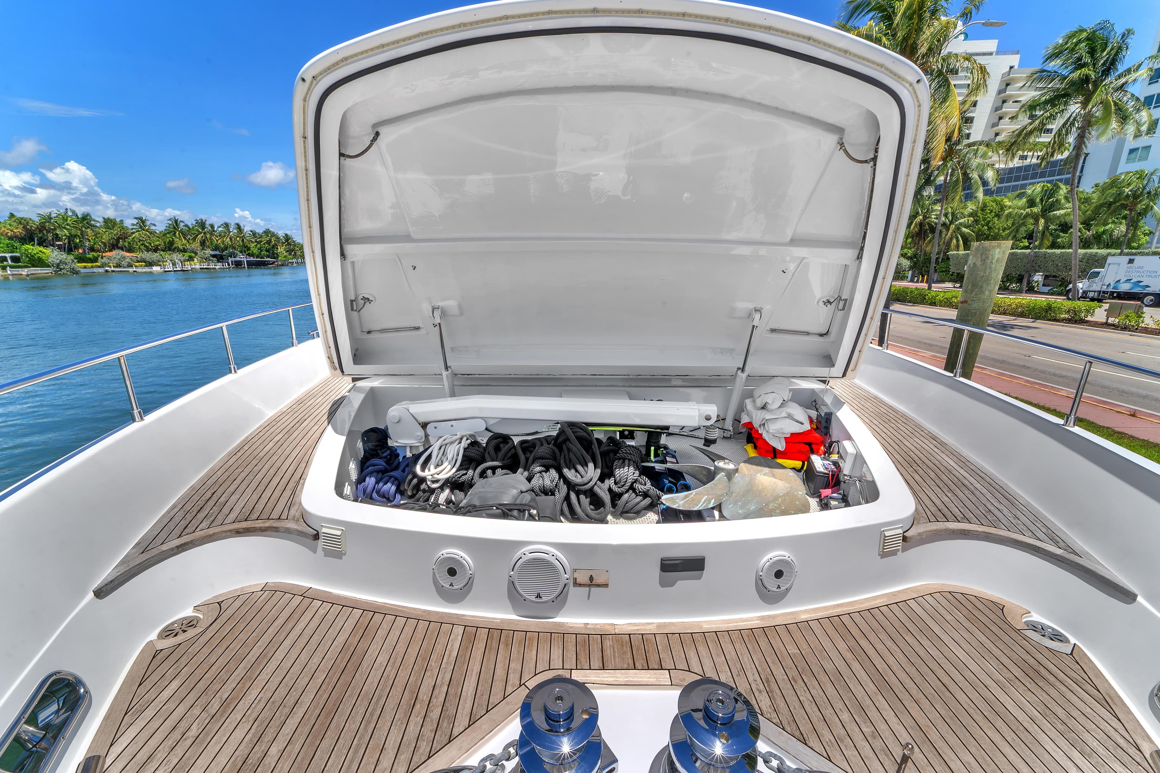 Open storage compartment on 2002 Ferretti Yachts Custom Line 94, docked by palm trees.
