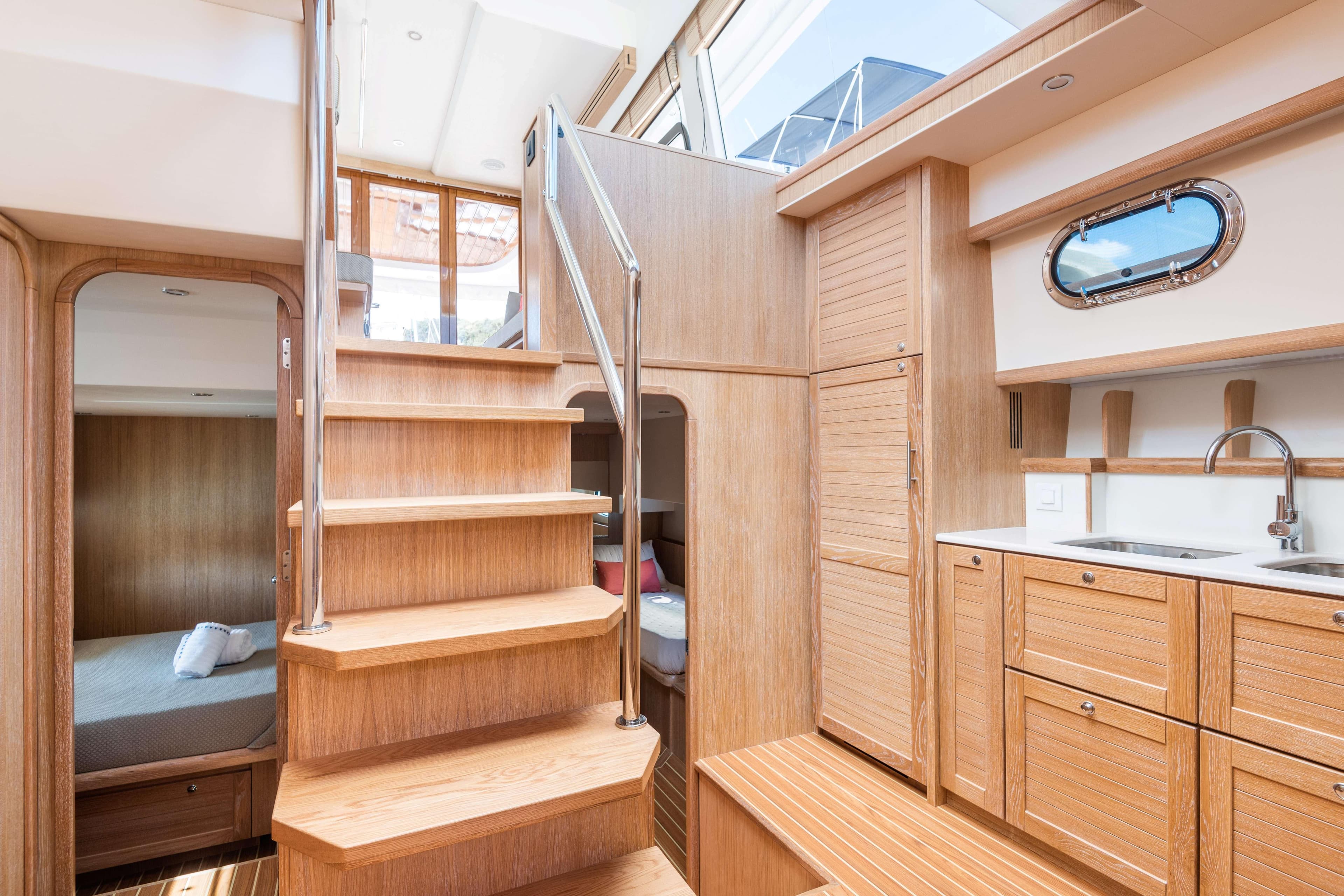 Interior of 2026 Sasga Yachts Menorquin 55 HT, featuring wooden cabinetry and stairs.