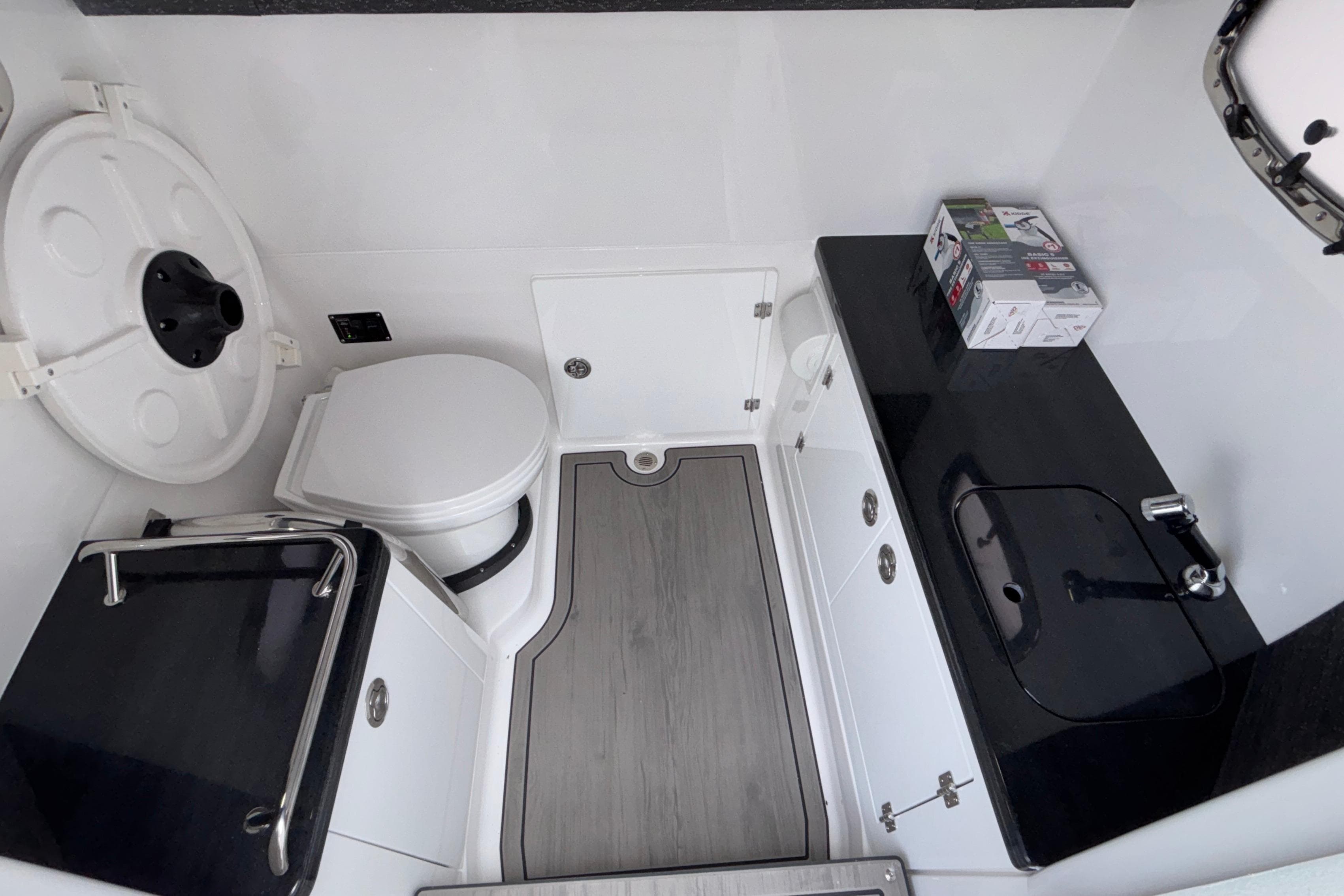 2026 Monterey Elite 30 OB boat bathroom with toilet, sink, and storage cabinets.