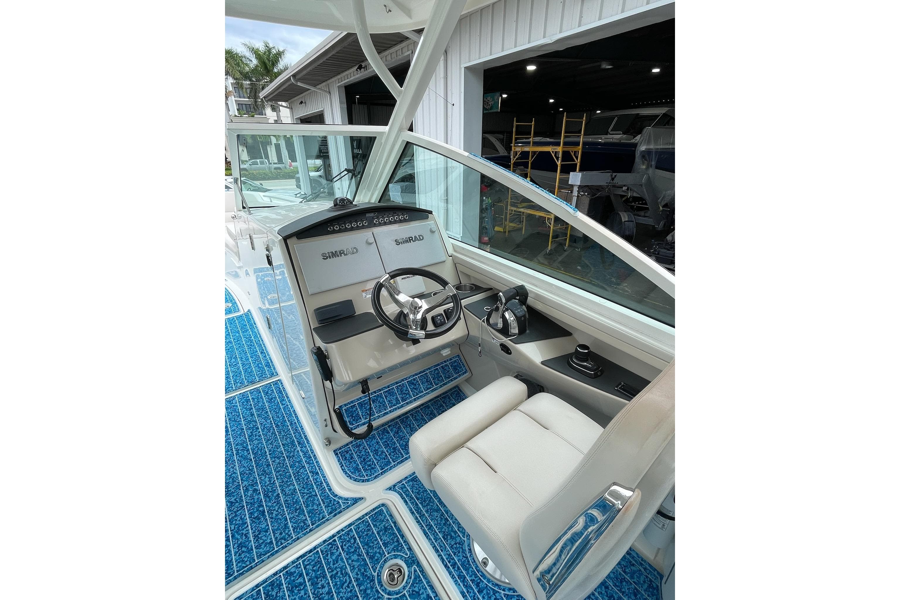 2017 Boston Whaler 320 Vantage boat cockpit with steering wheel and Simrad electronics.