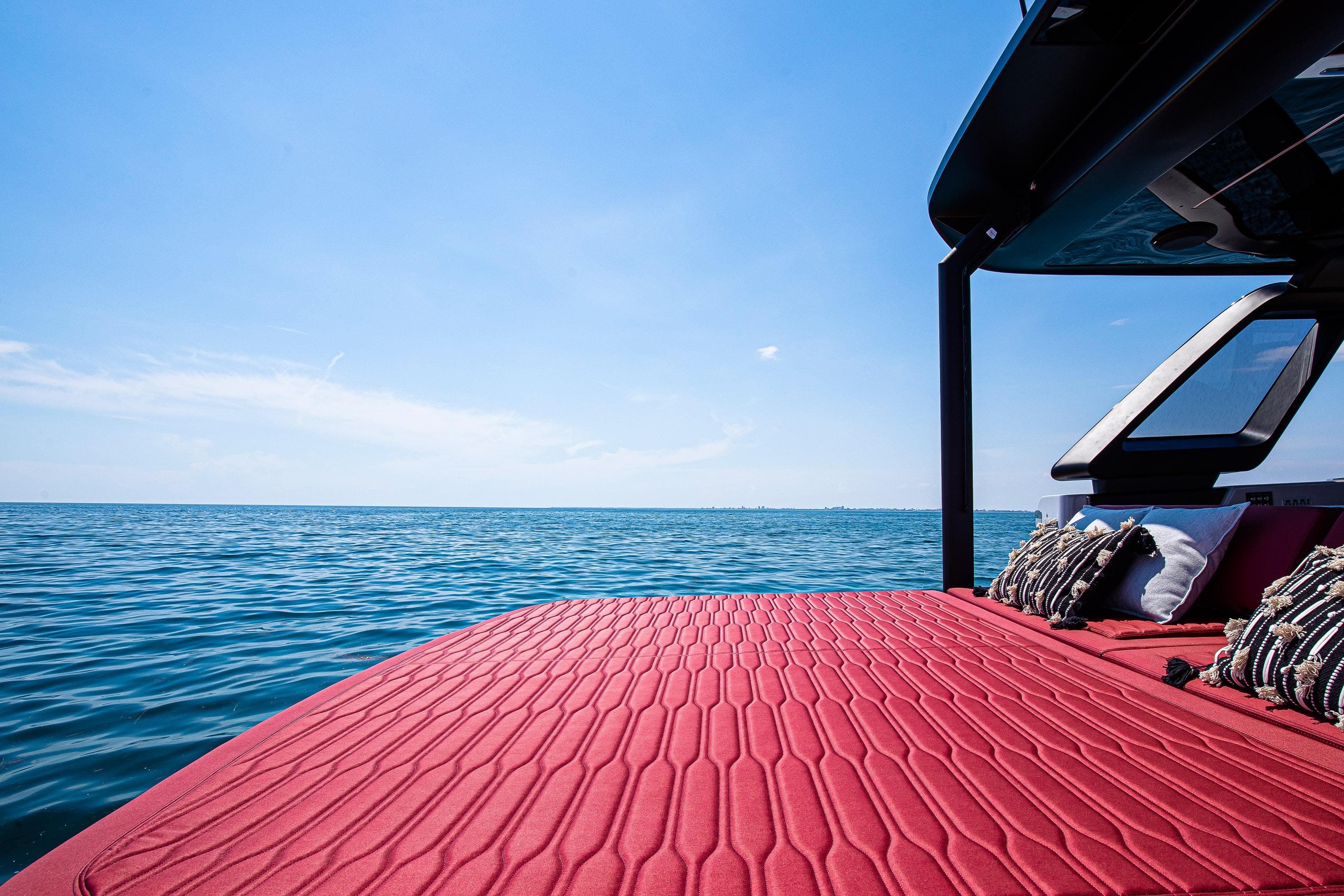 2026 Cranchi A46 Luxury Tender with red deck, ocean view, and cushions.