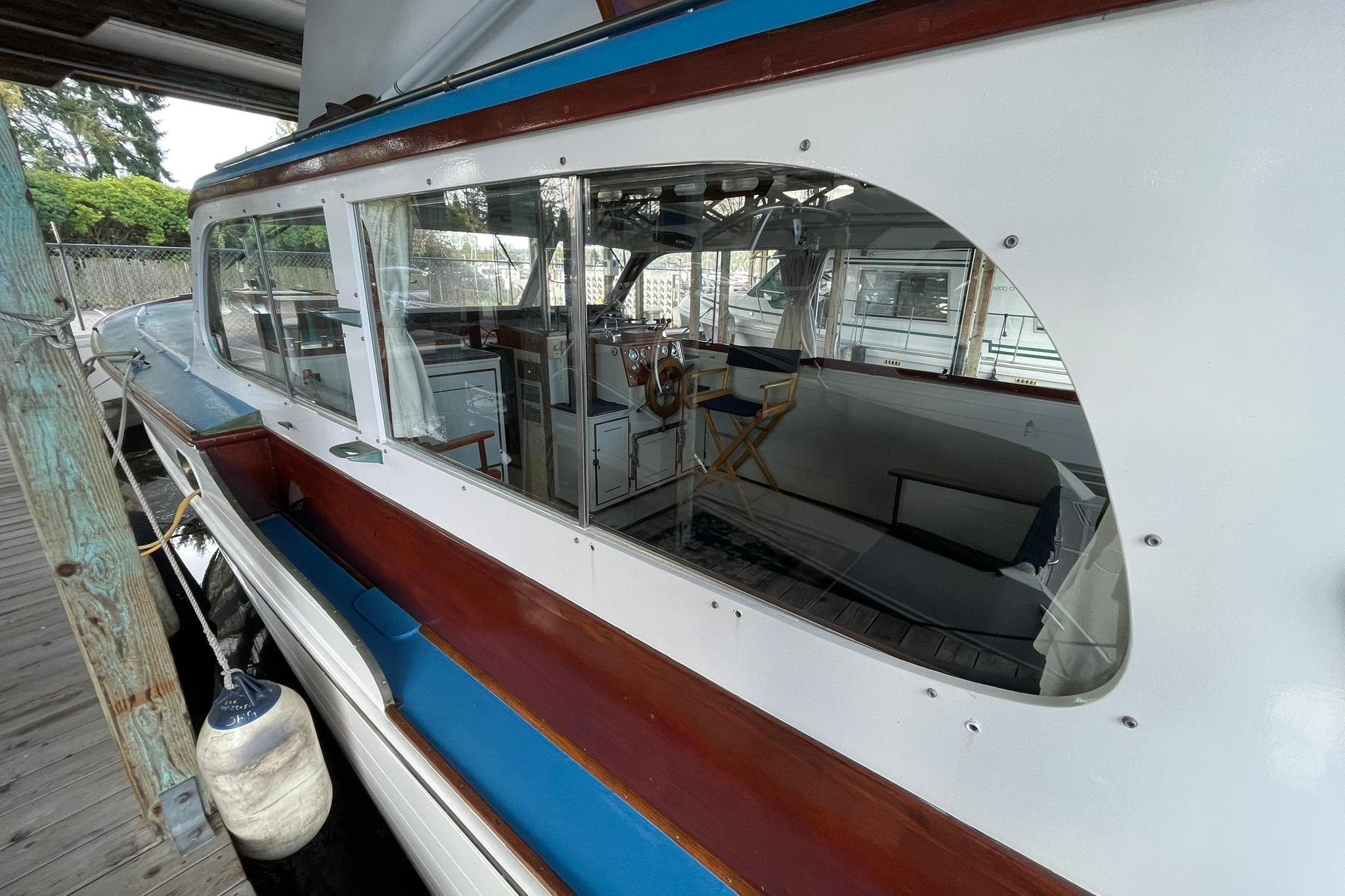 1947 Matthews De Luxe Sedan boat interior with wooden accents and steering wheel.