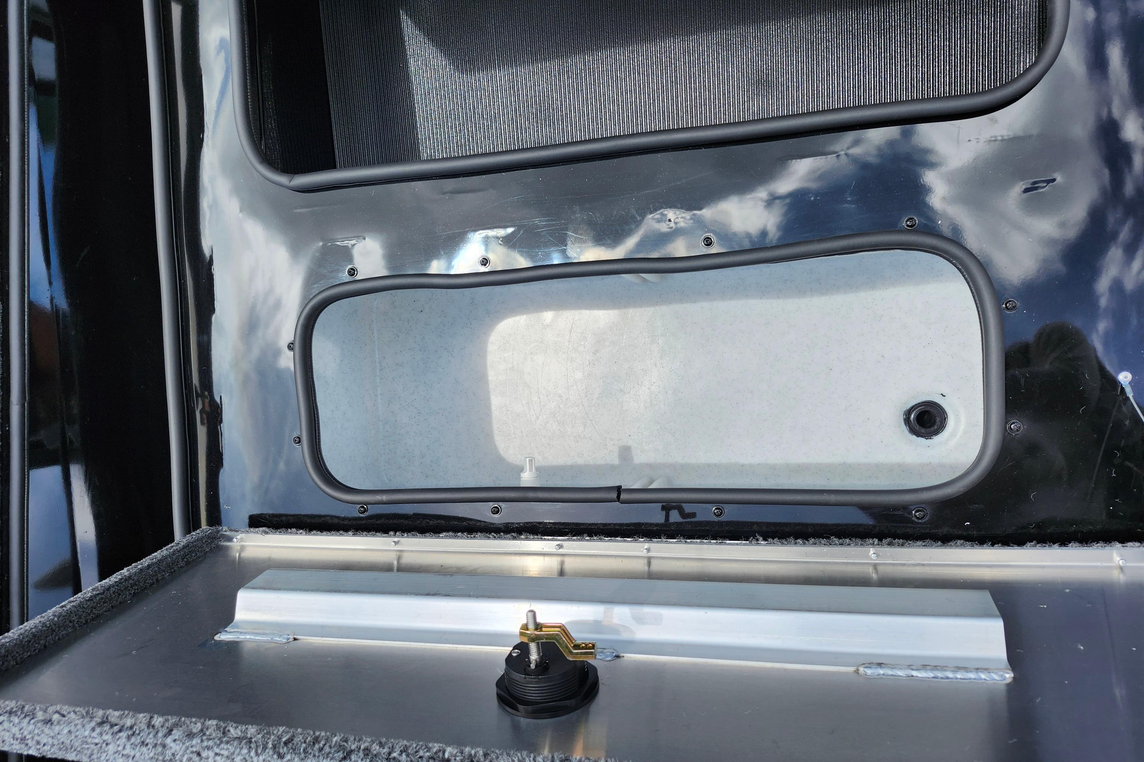 Lowe Stinger 175C 2026 boat compartment with latch and reflective surface.
