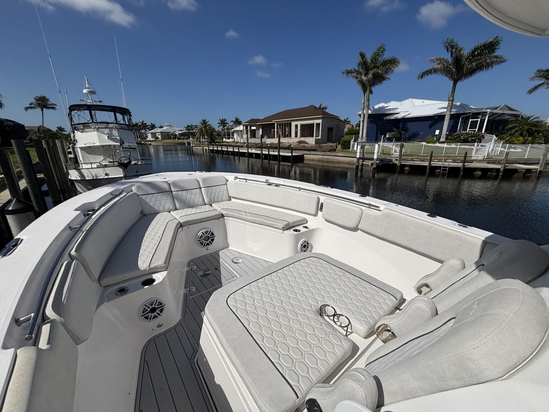 2023 Sea Fox 328 Commander boat with spacious seating, docked by waterfront homes.
