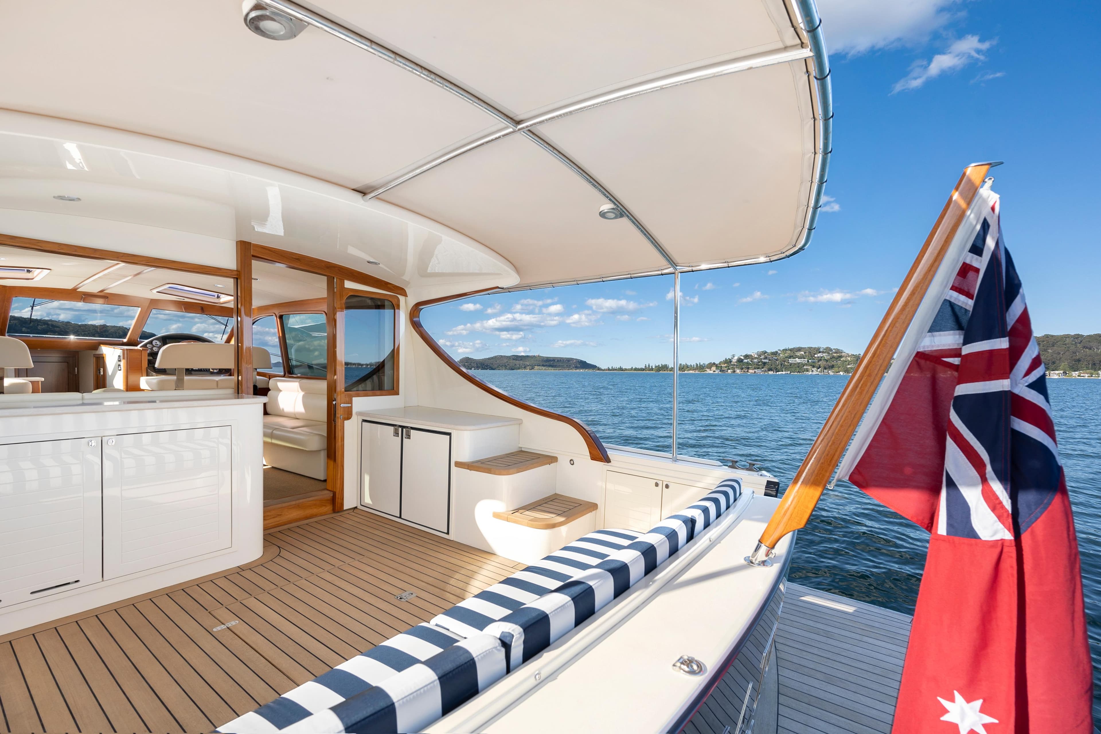 2026 Palm Beach Motor Yachts PB45, luxury deck view, nautical flag, serene waters.