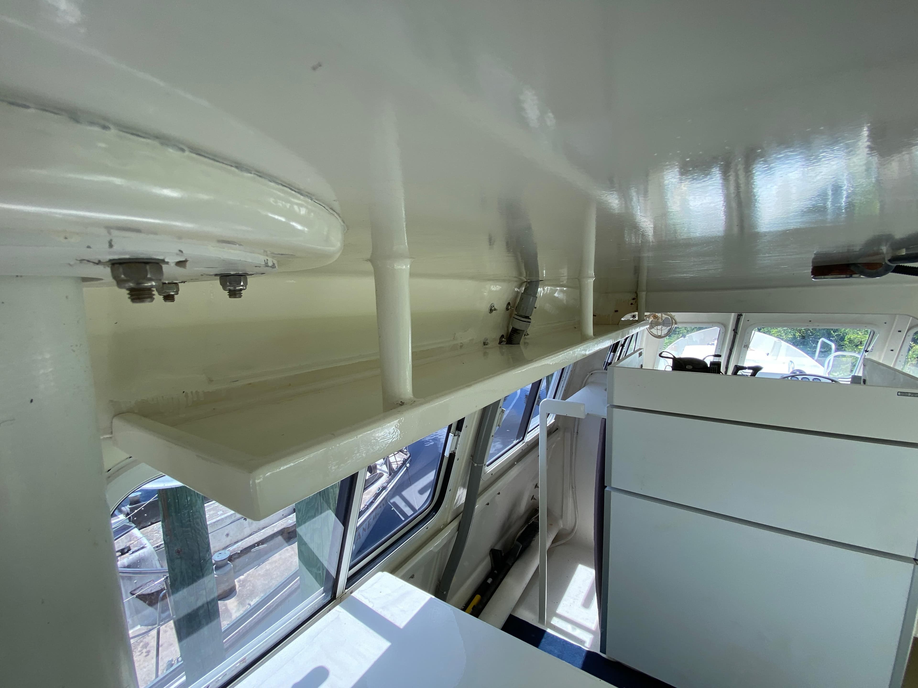 Interior of a 1996 Custom 62 boat, showcasing white cabinetry and windows.