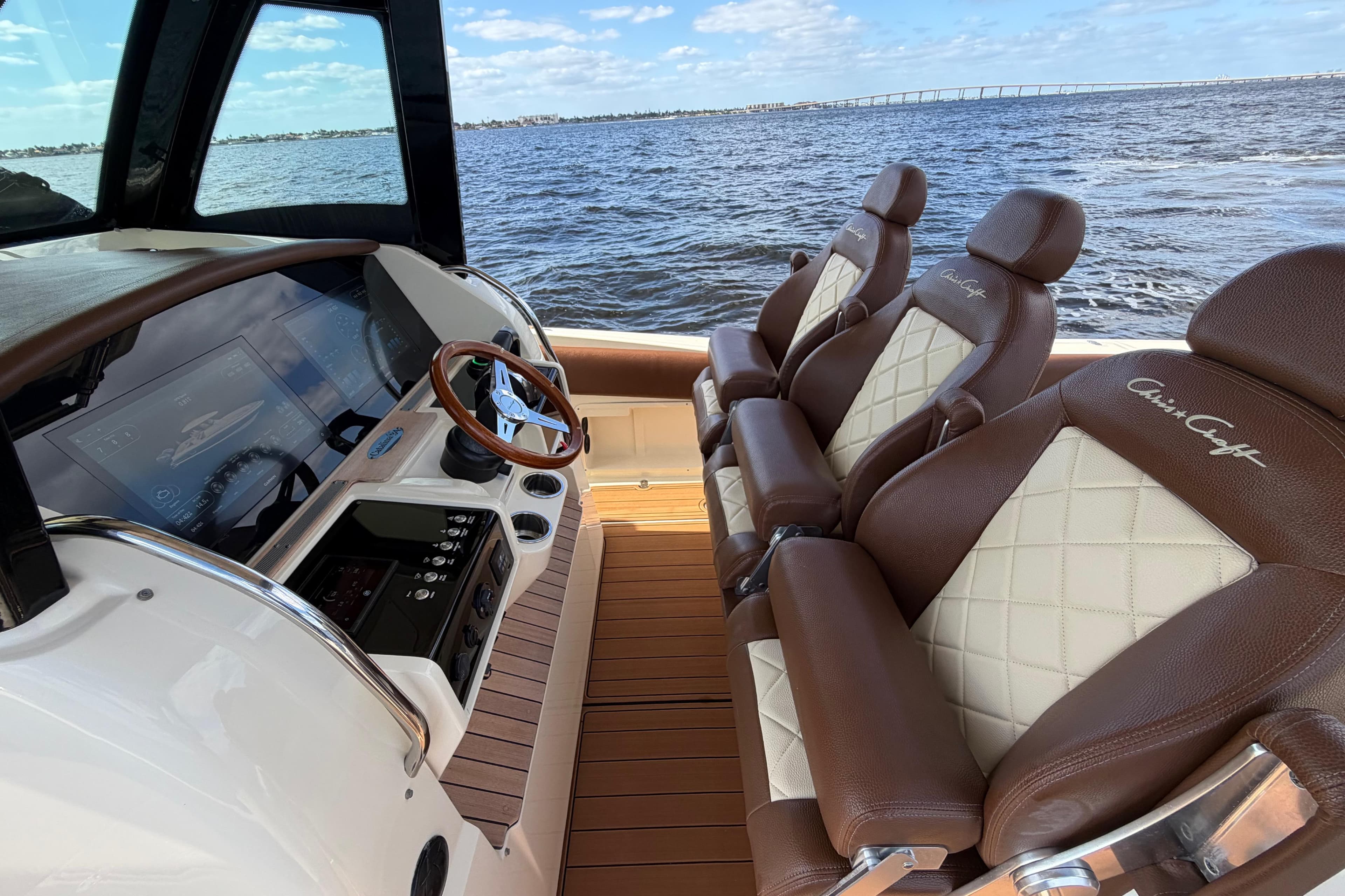 2021 Chris-Craft Catalina 34 interior with luxurious seating and modern dashboard, overlooking the ocean.