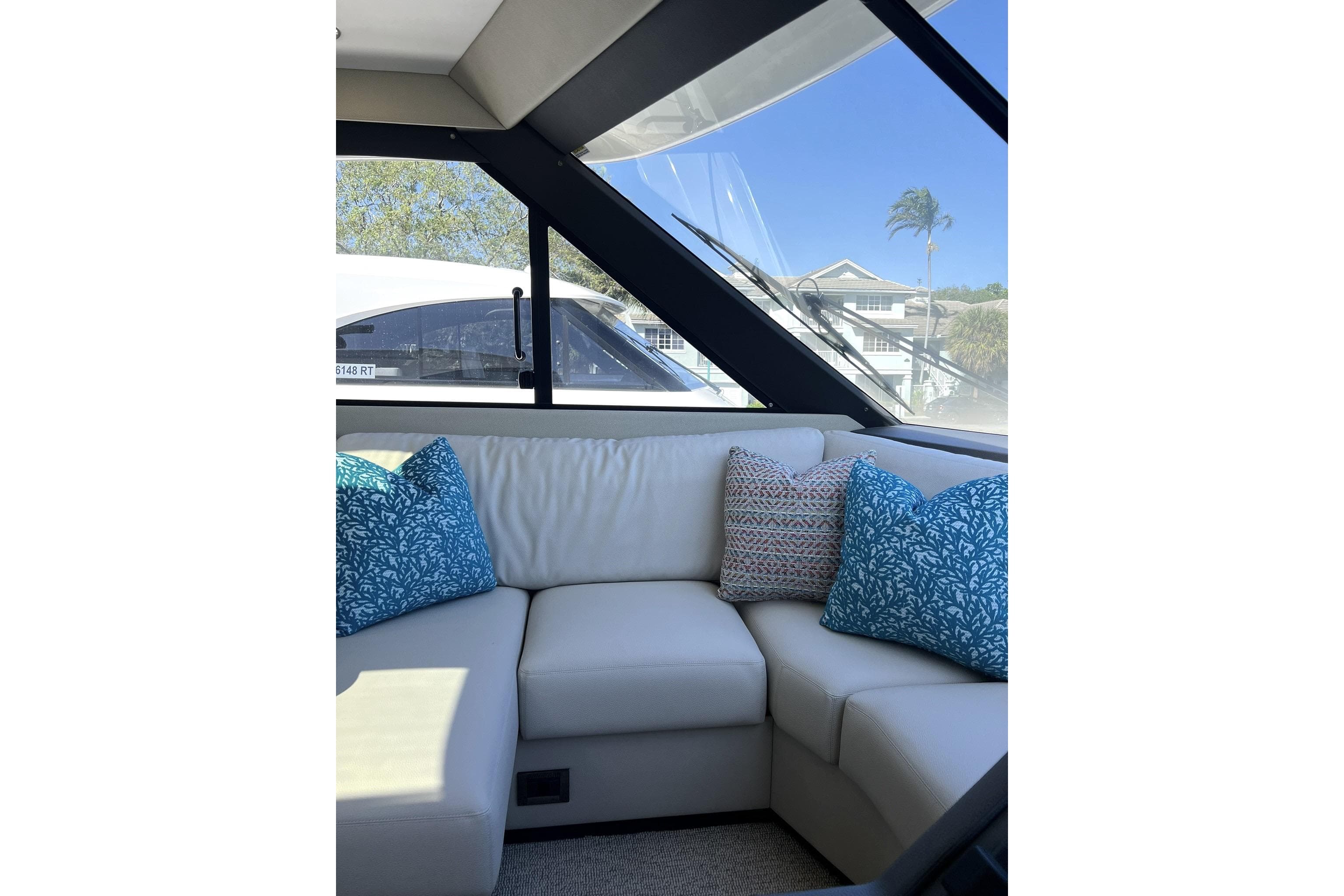 Luxurious interior of 2025 Maritimo M55 yacht with plush seating and decorative pillows.