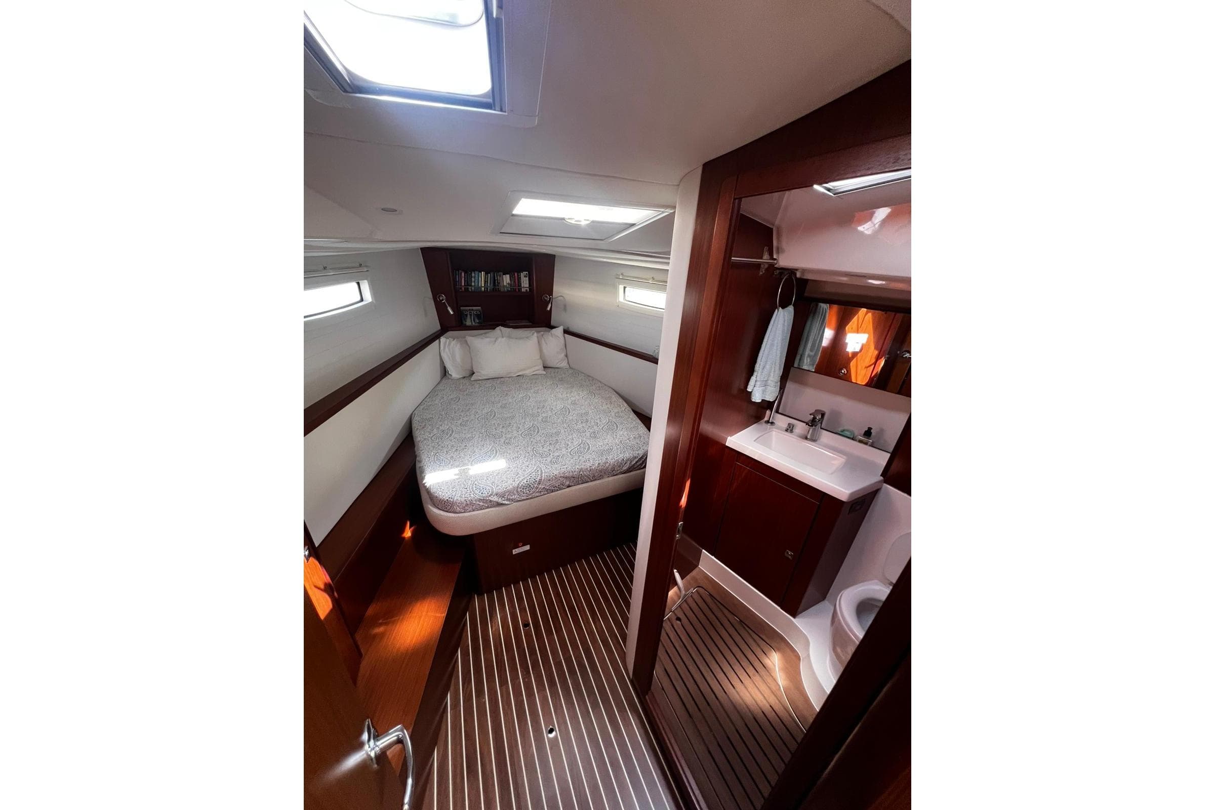 Interior of 2015 Bavaria Vision 46 yacht featuring cozy bedroom and compact bathroom.
