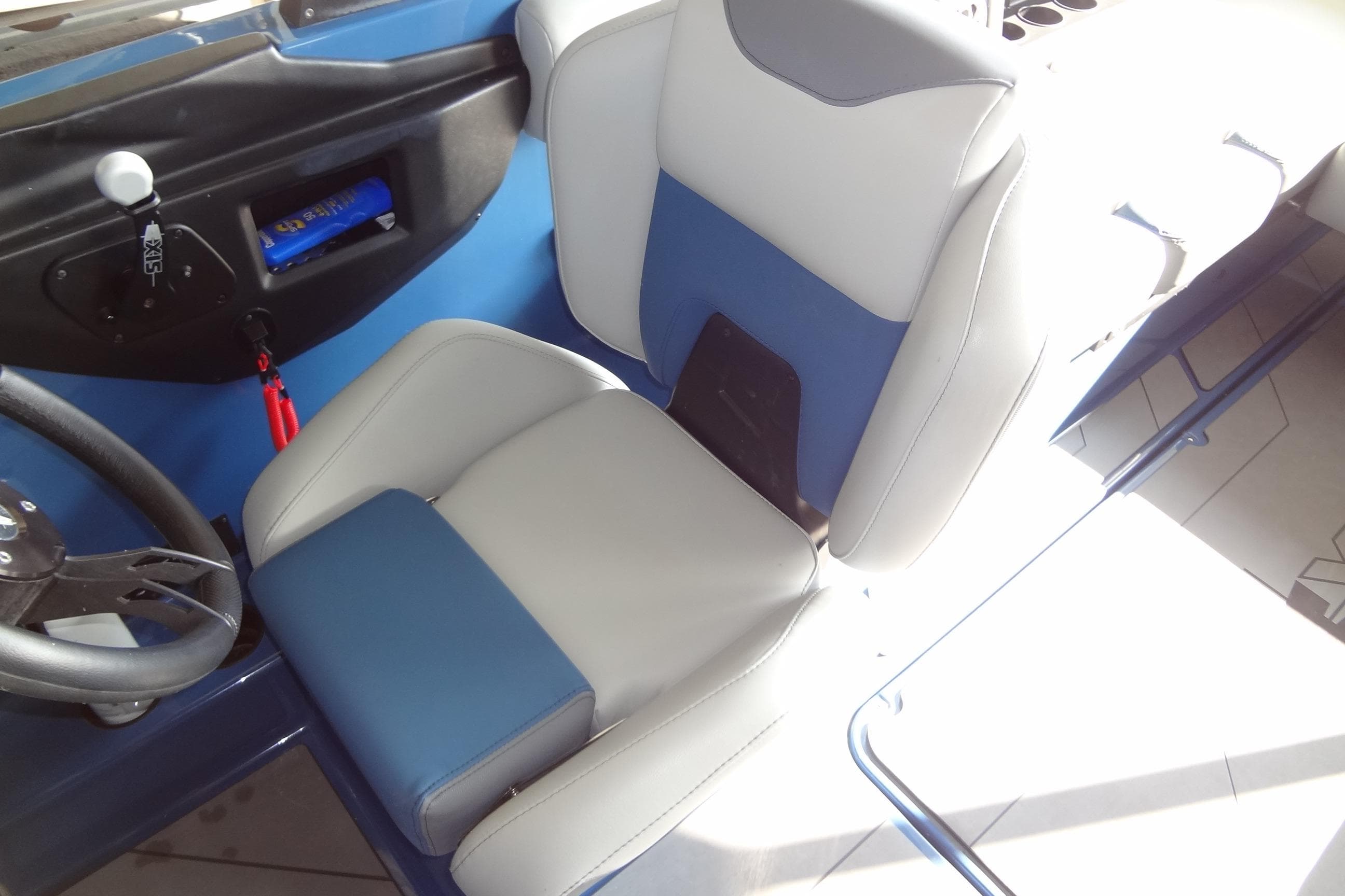 2021 Axis A24 boat interior with blue and gray seating and steering wheel.