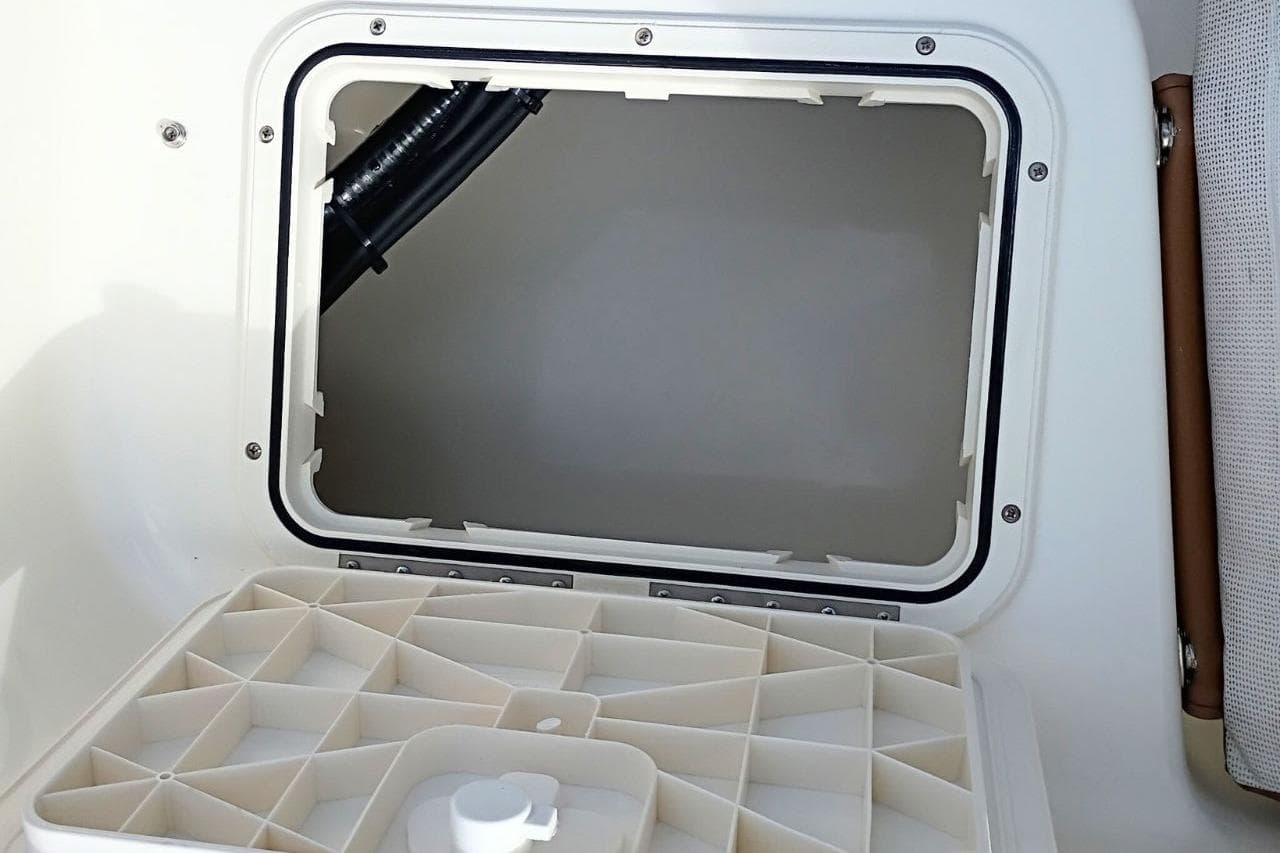 2026 Pioneer 202 Sportfish boat storage compartment with open hatch and organized interior.