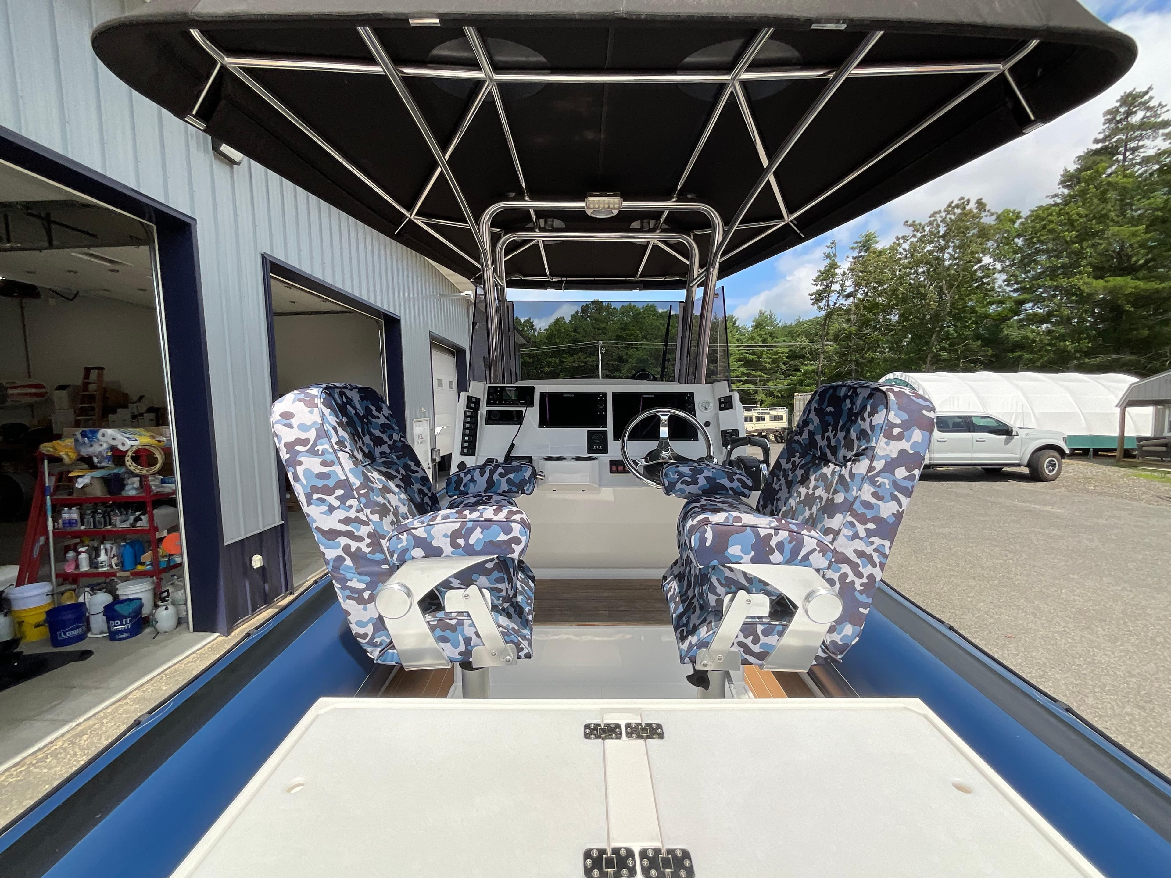 2019 Protector 310 Chase boat interior with camo seats and steering console.