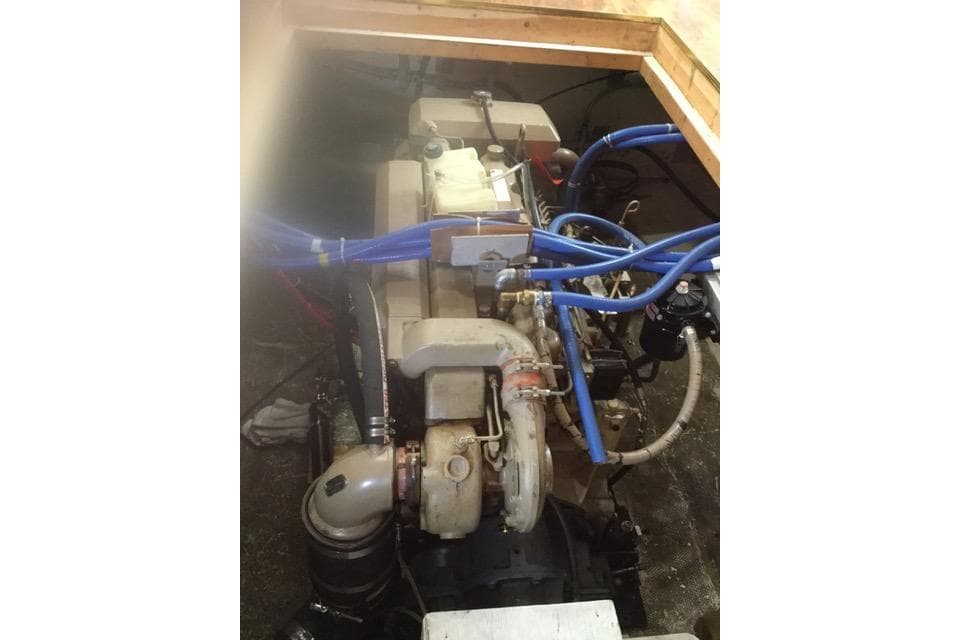 Engine compartment of 2013 Custom Trawler 45 with visible blue hoses and components.