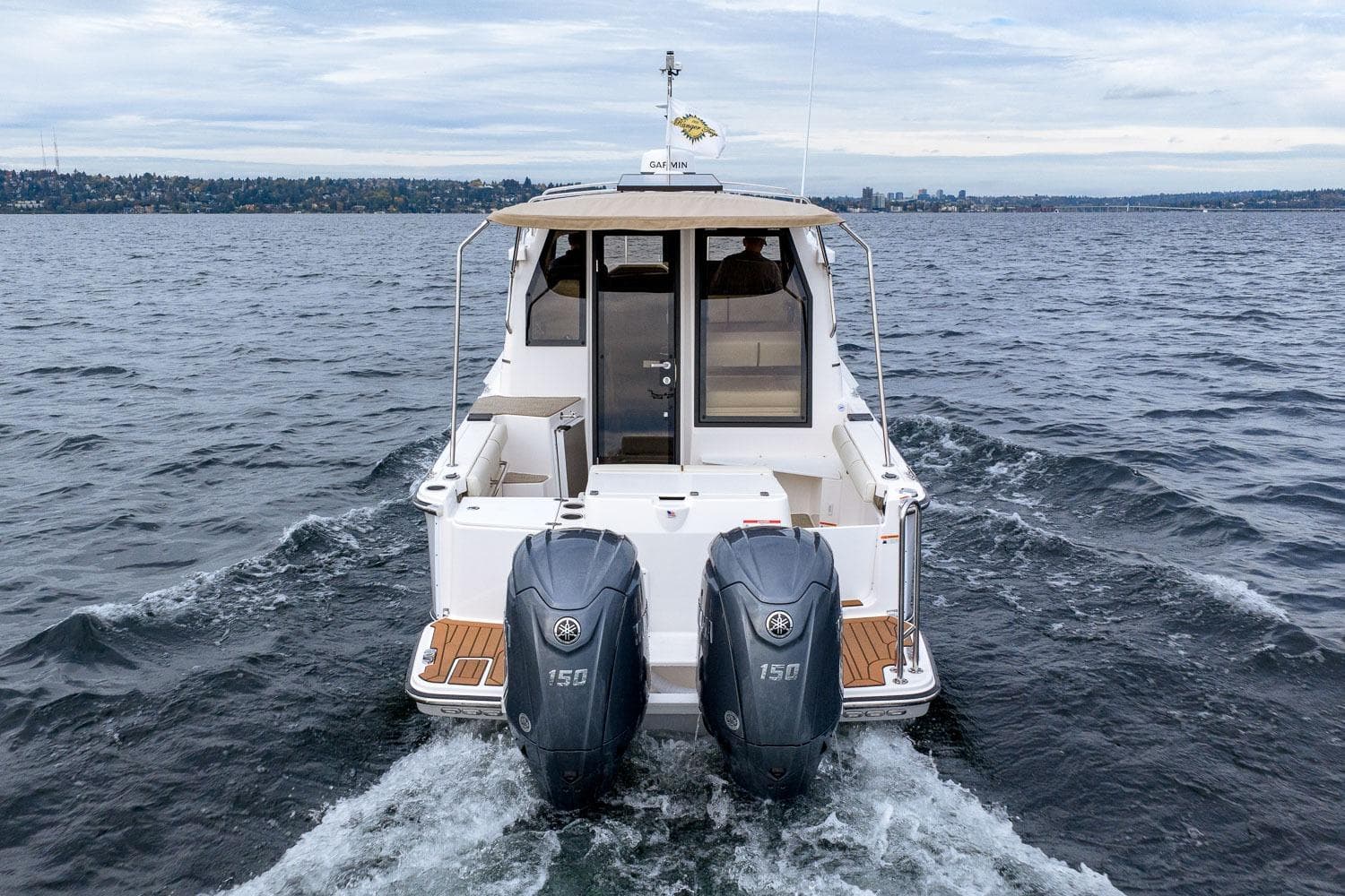 2026 Ranger Tugs R-27 boat cruising on open water with dual outboard engines.