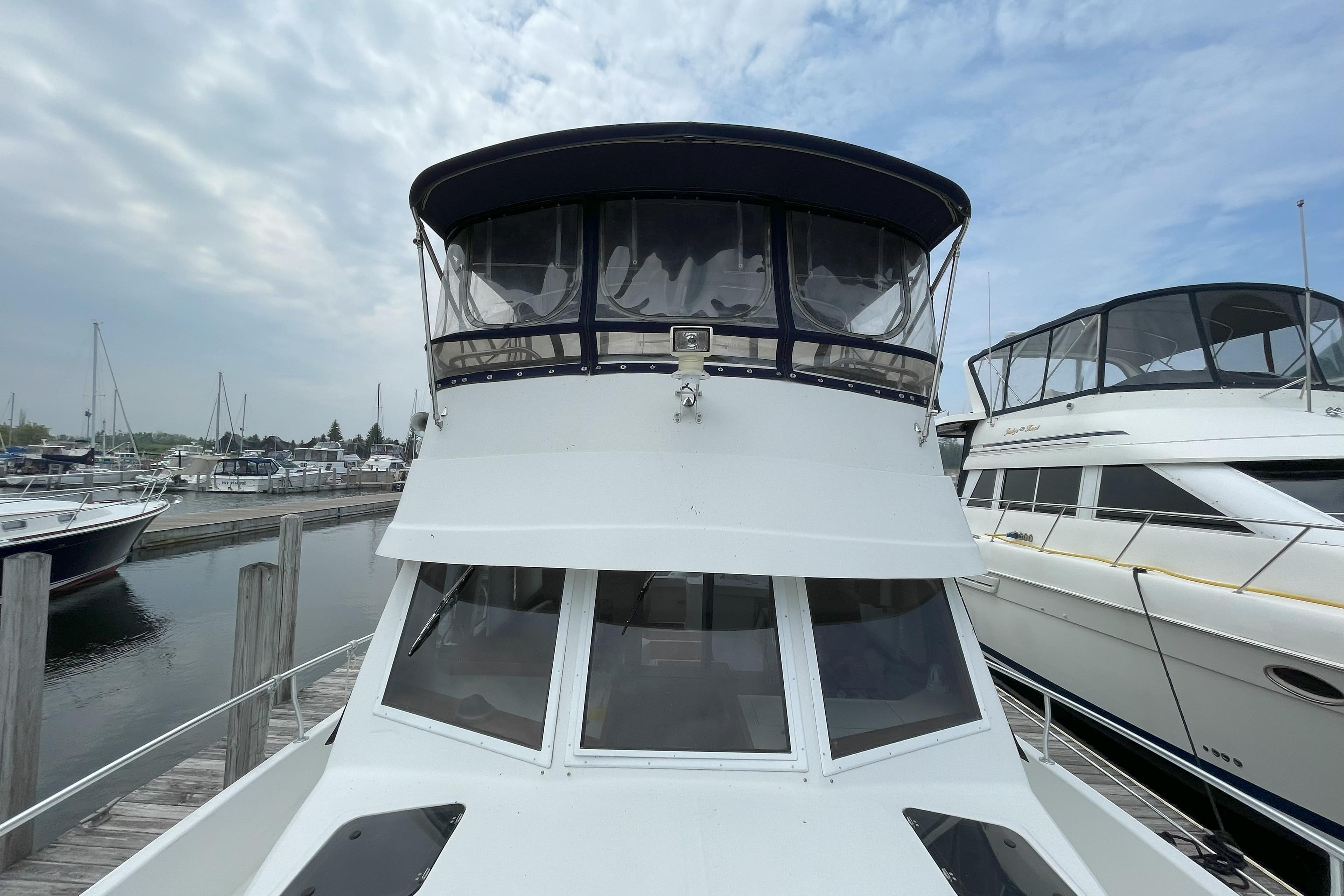 2000 Mainship 390 Trawler docked at marina, showcasing front view and upper deck.