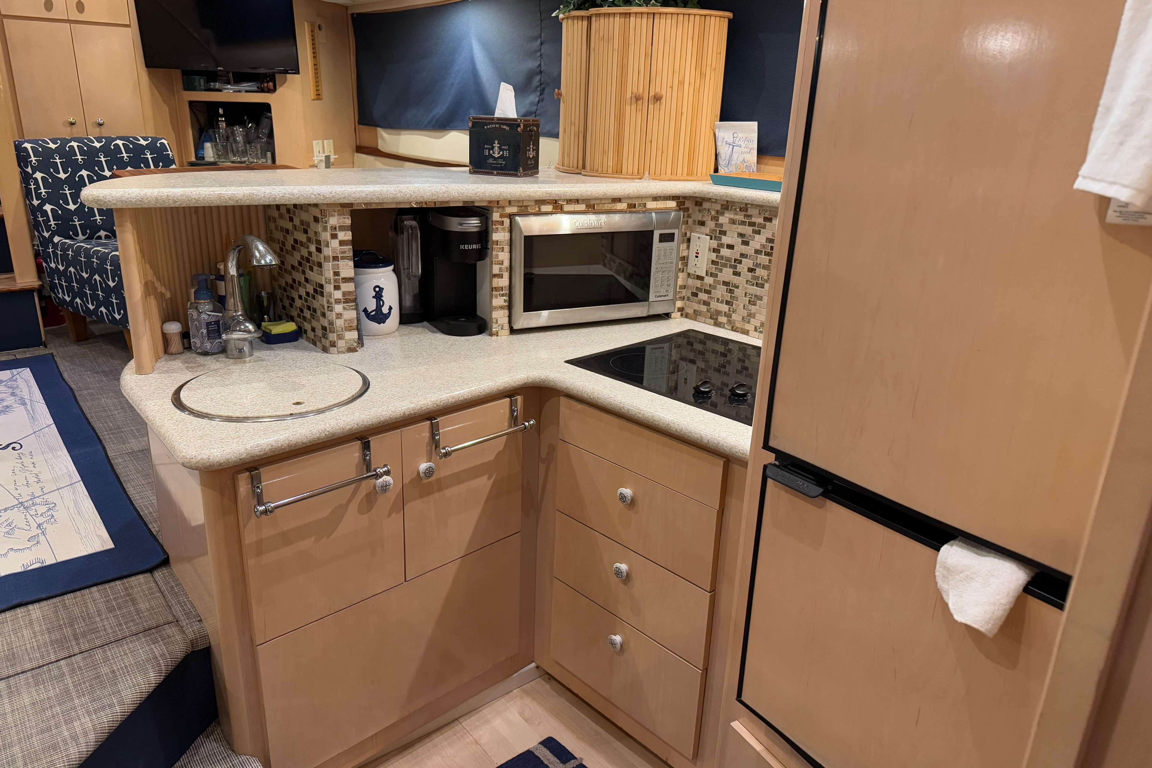 Interior of 2000 Carver 396 Motor Yacht kitchen with modern appliances and nautical decor.