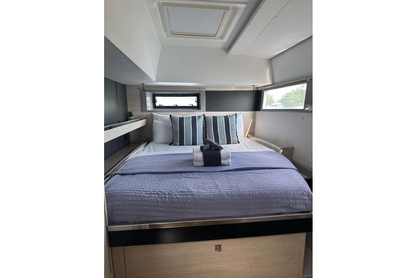 Luxurious bedroom interior of 2018 Leopard 45 yacht with modern bedding and natural light.