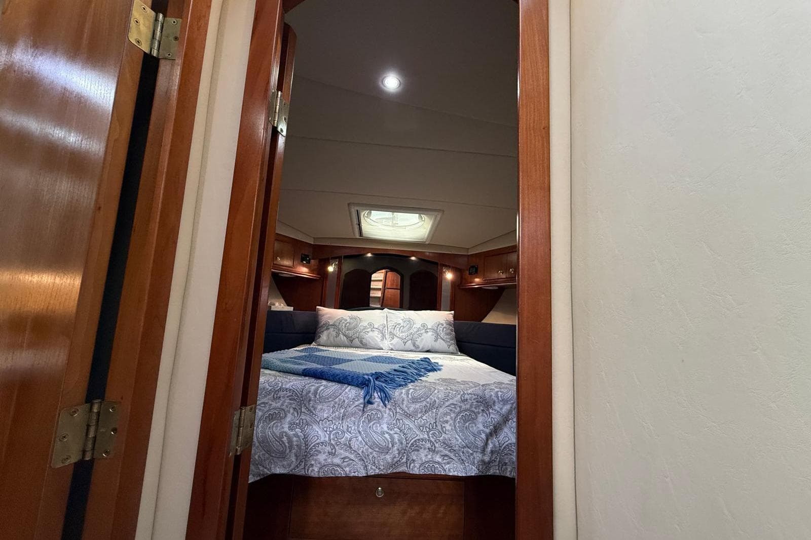 Luxurious bedroom interior of 2005 Cruisers Yachts 455 Express Motoryacht with elegant bedding.