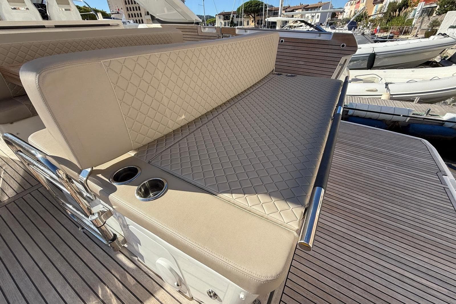 Luxurious seating on 2023 Jeanneau DB/43 IB yacht with quilted upholstery and cup holders.