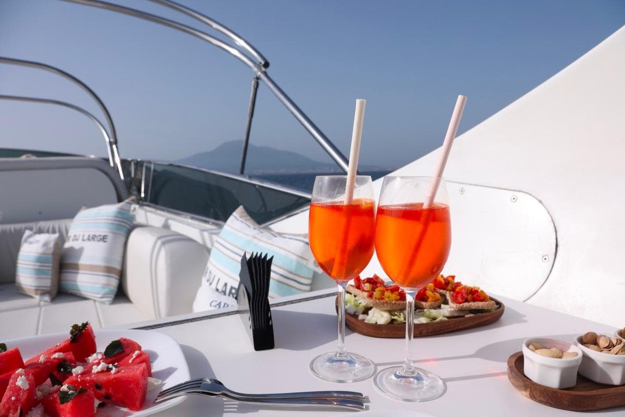 Luxurious Maiora 29 DP yacht deck with drinks, snacks, and scenic ocean view.