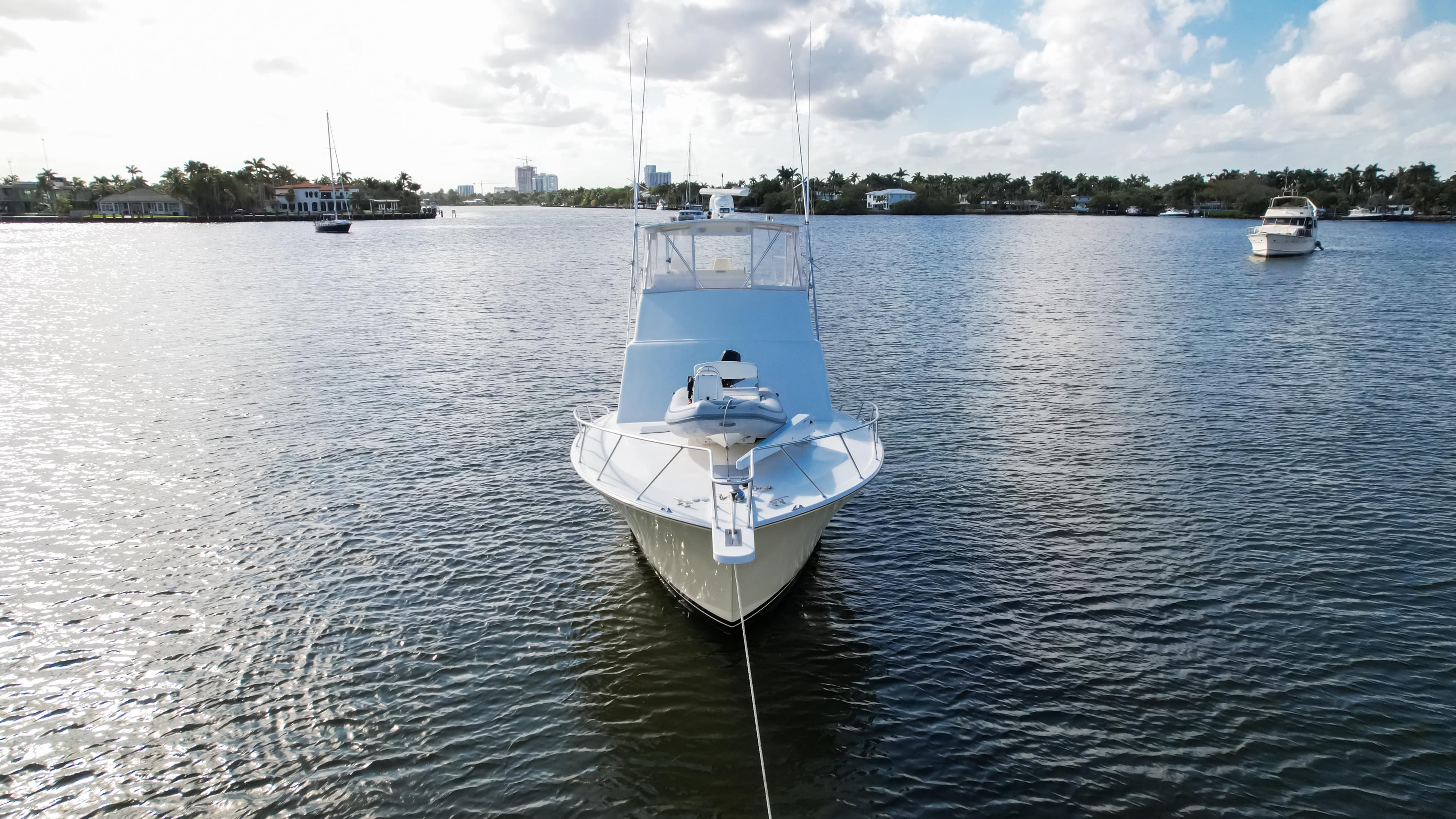 Front view of a 2008 Post 42 yacht on calm water under a partly cloudy sky.