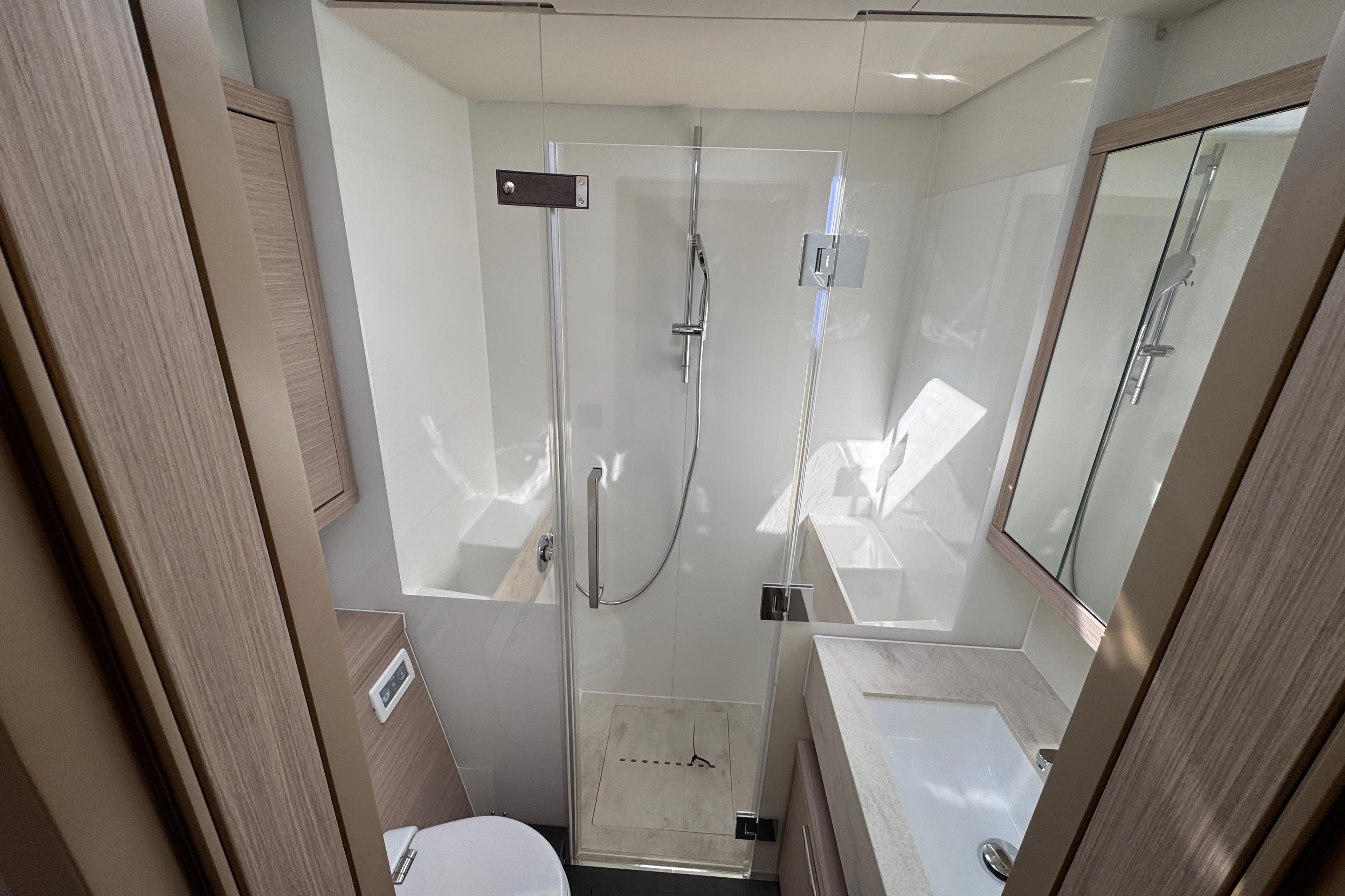 Modern bathroom in 2026 Lagoon 55 yacht with glass shower and sleek design.