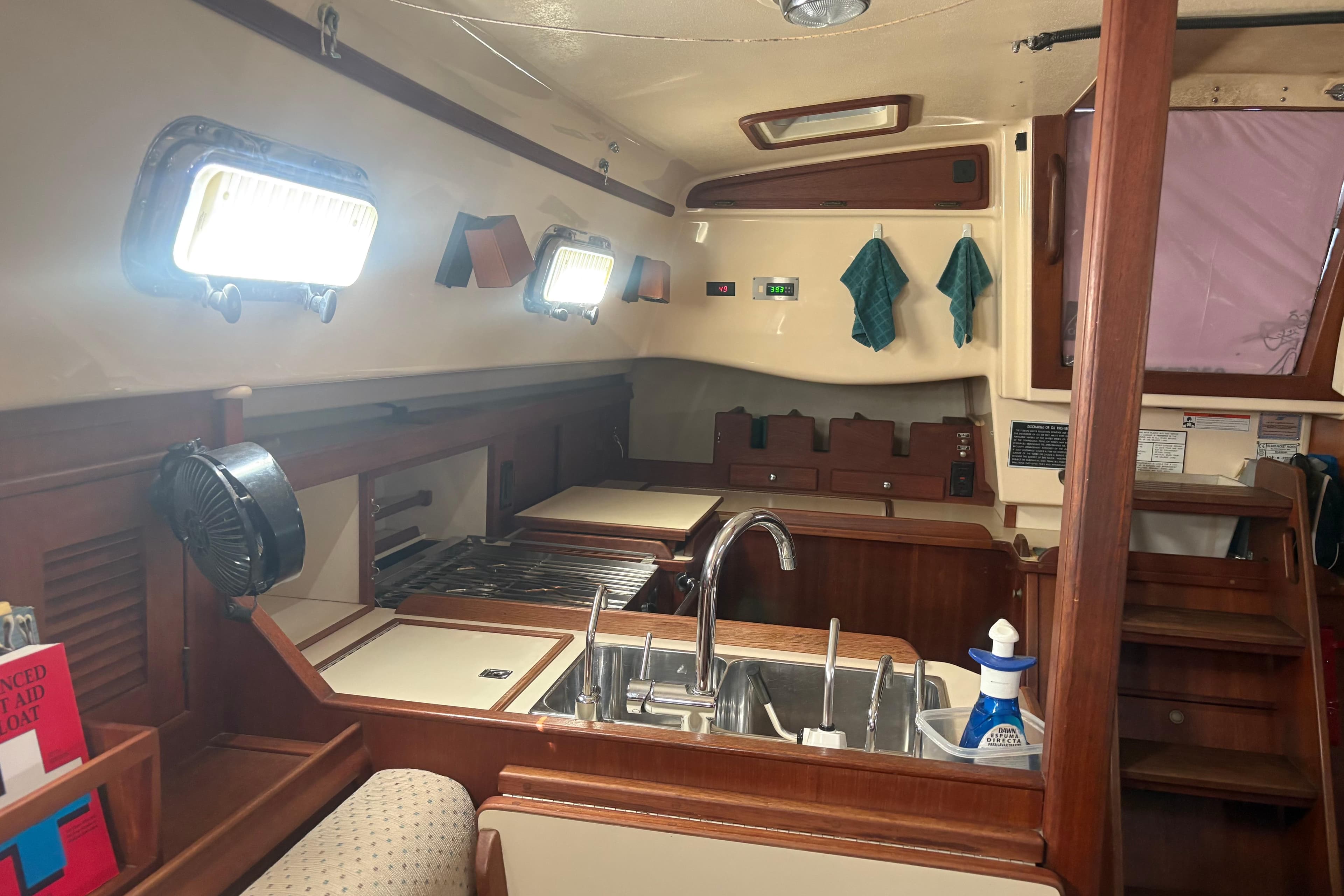 Interior of 1999 Island Packet 380 sailboat kitchen with sink, stove, and storage.