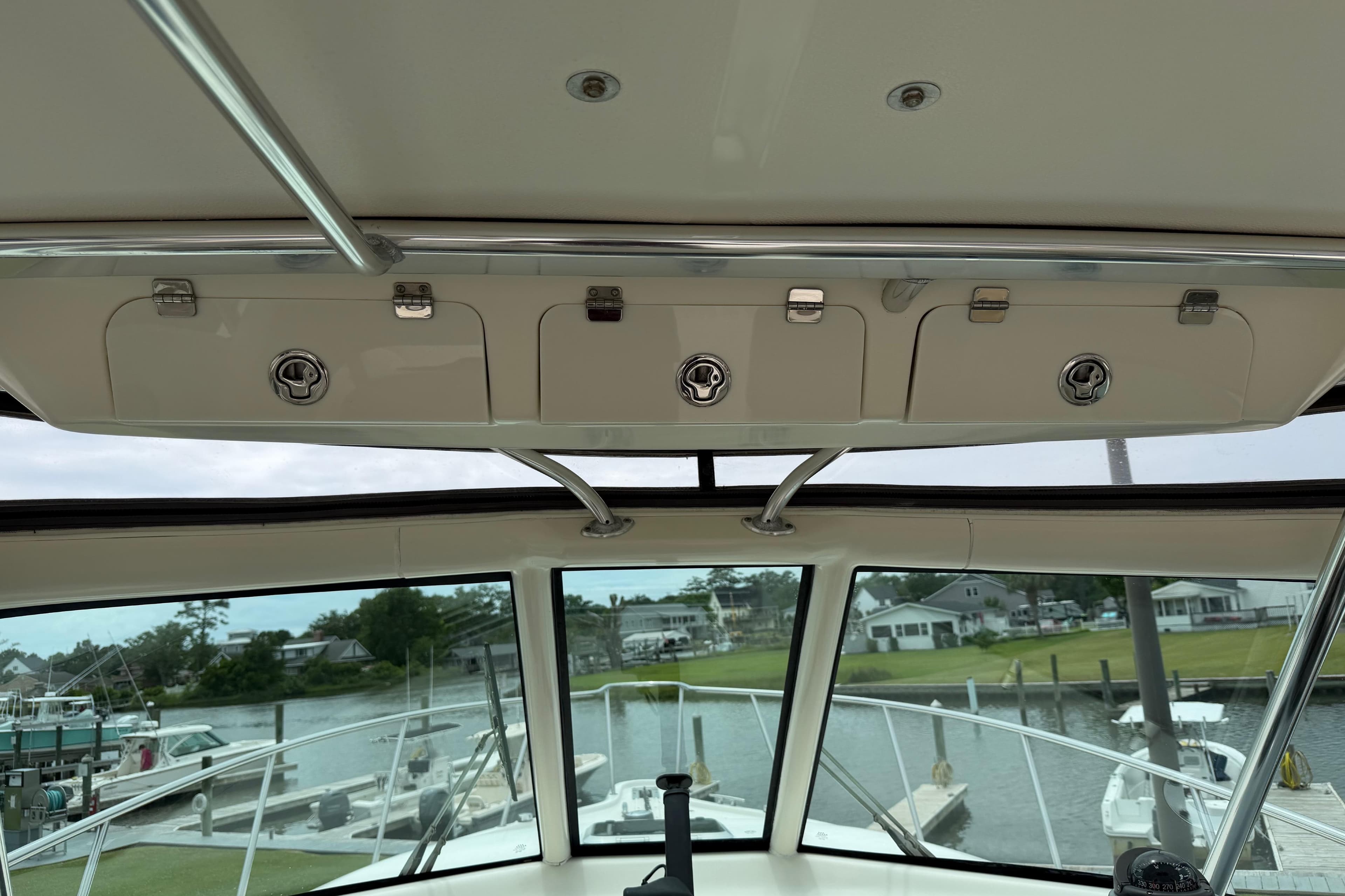 2008 Pursuit OS 335 Offshore boat interior with overhead storage and marina view.