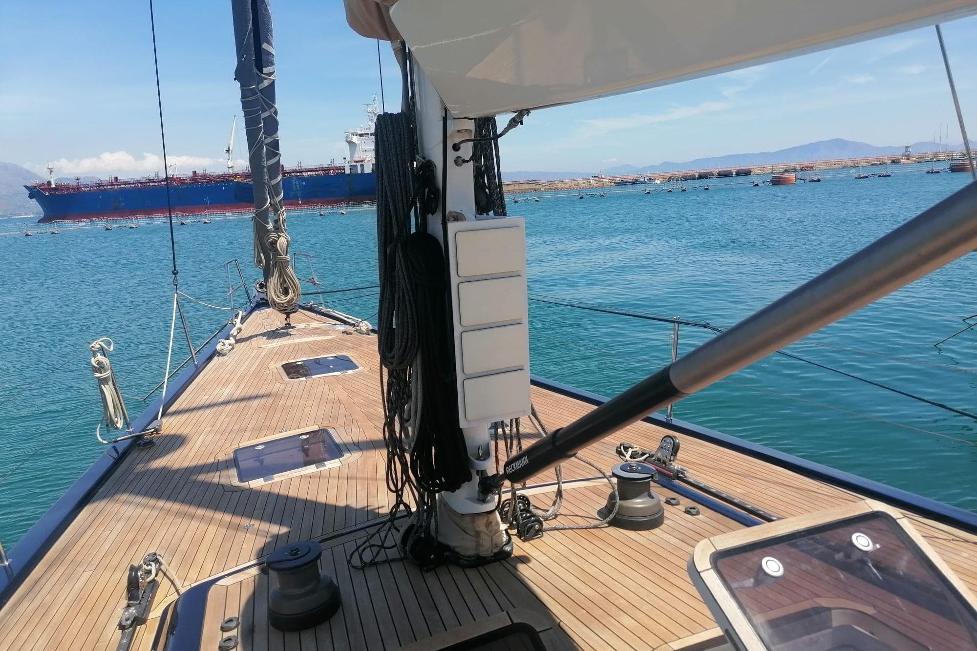 Deck view of 2008 Ice Yachts Felci 71 sailboat with ocean and ship in background.