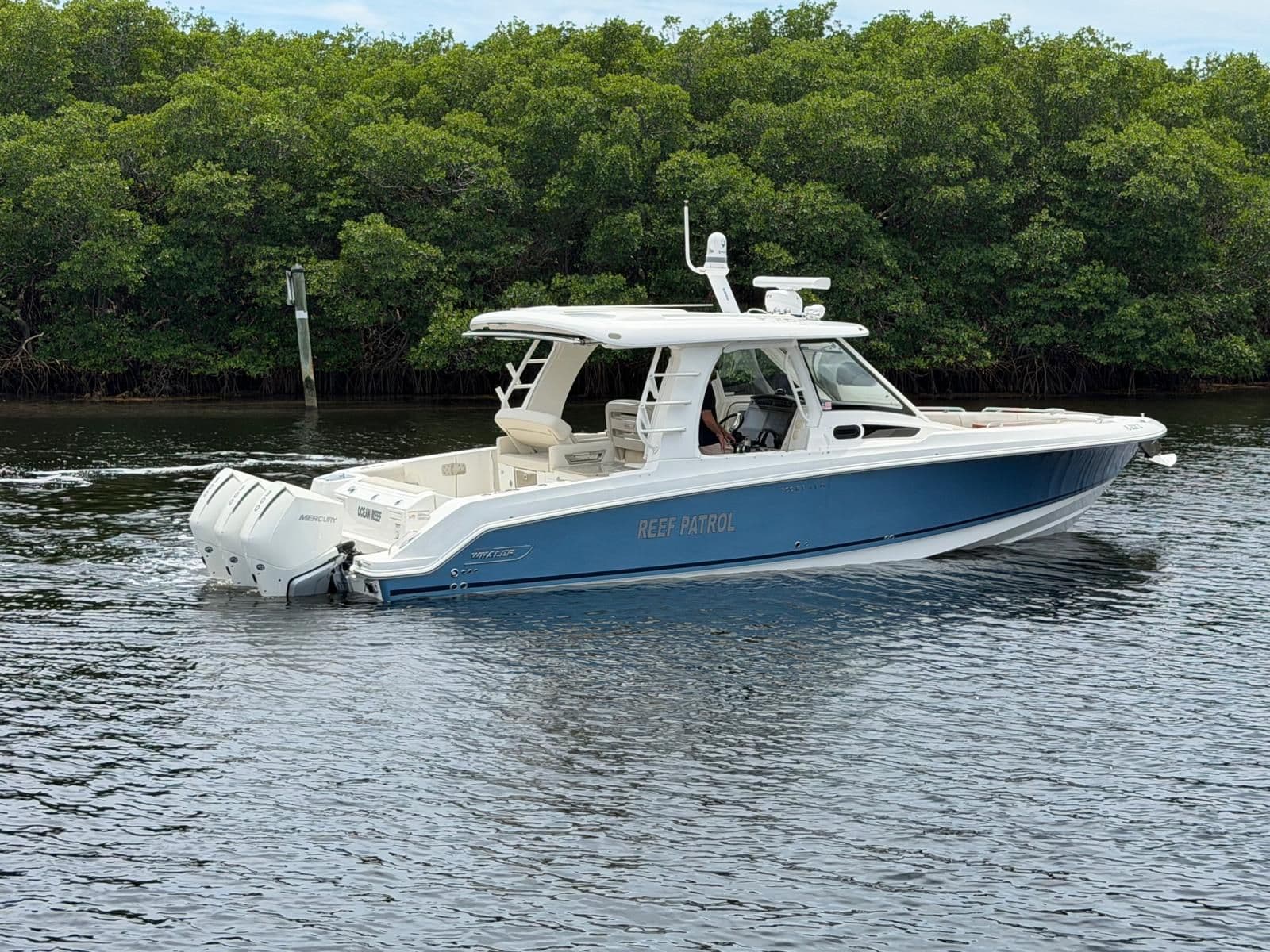 Boston Whaler 350 Realm 2022 on calm water near mangroves.