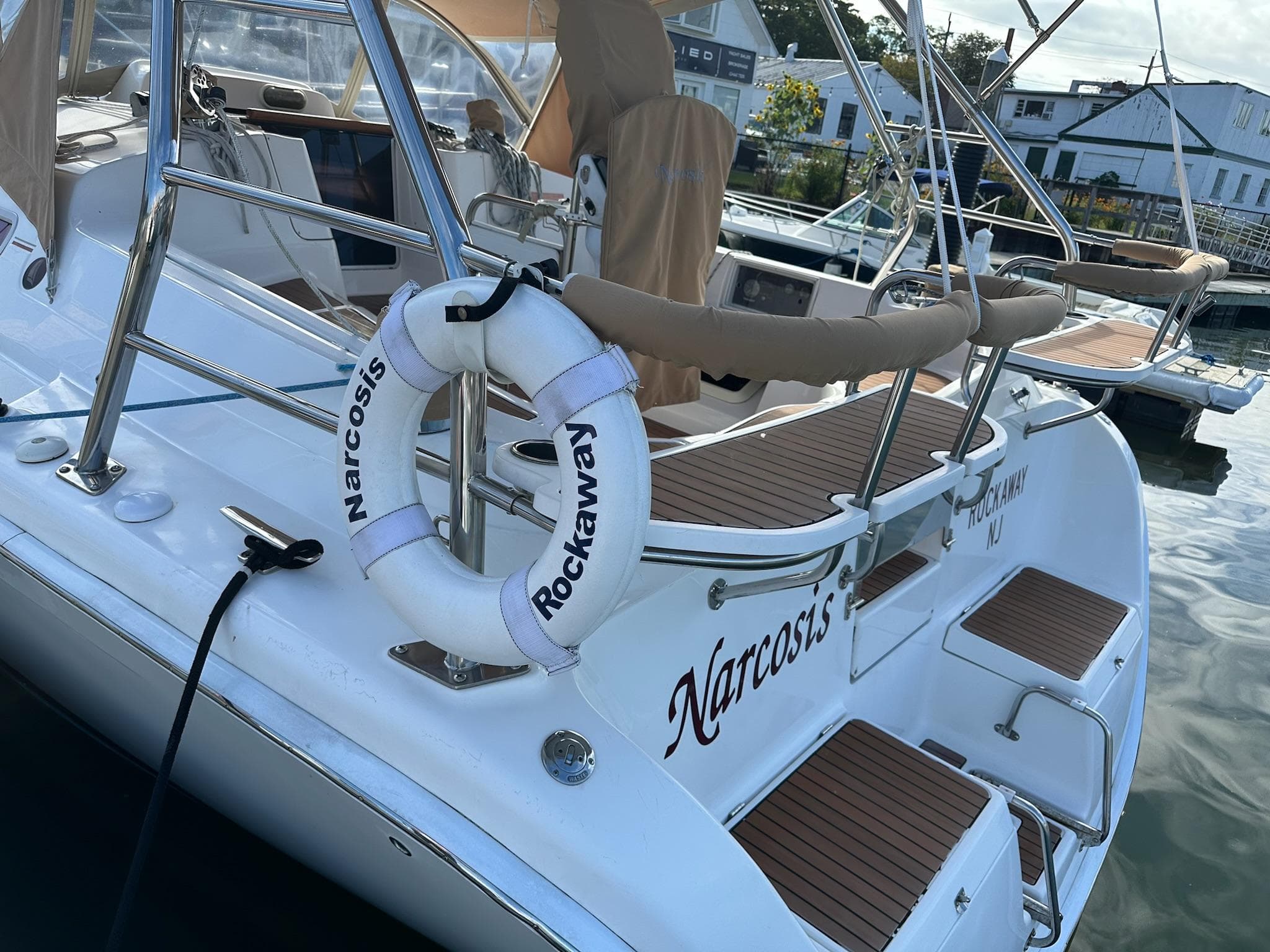 Hunter 38 sailboat, 2005 model, docked with lifebuoy and wooden deck details.