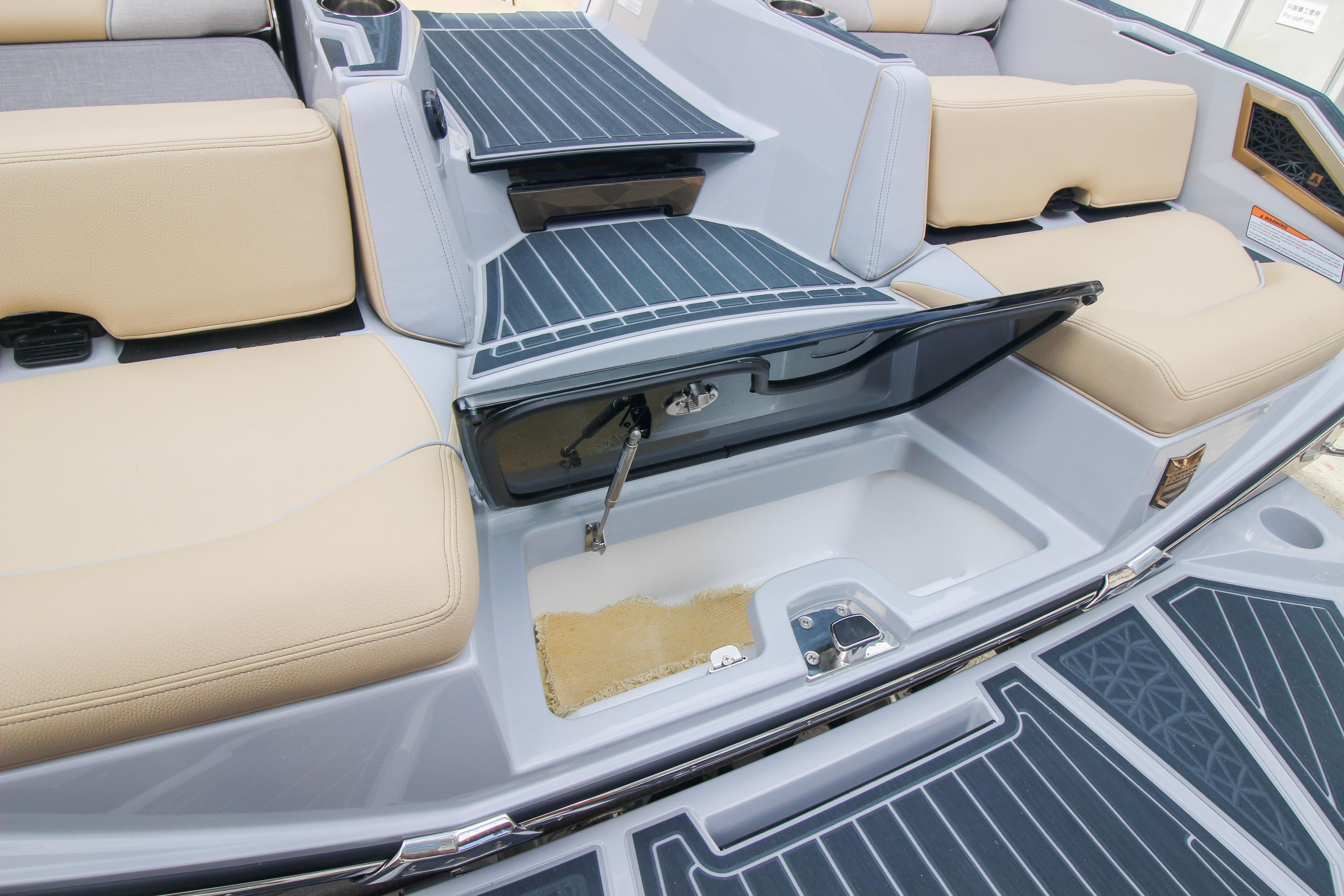 2022 Nautique Super Air Nautique G25 Paragon interior storage compartment with beige seating.