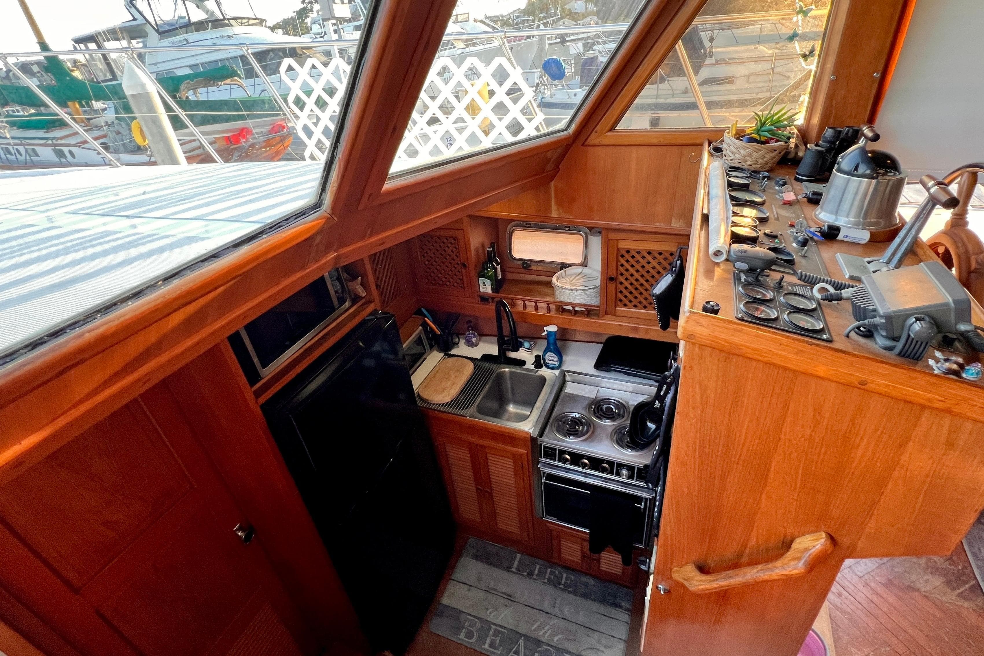 1985 Heritage East 40 Sundeck Trawler kitchen with wooden cabinetry and nautical decor.