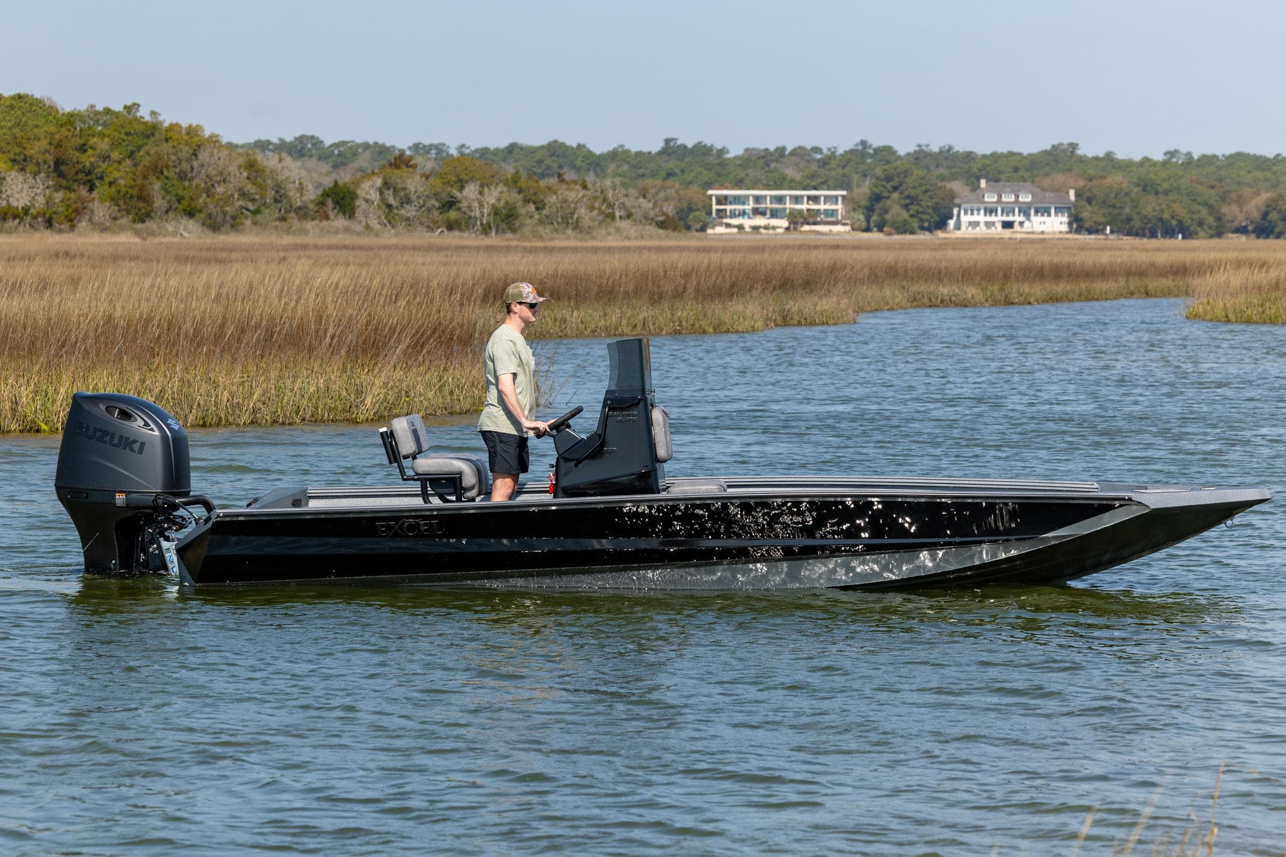2026 Excel 220 Bay Pro Elite boat cruising on a serene waterway with scenic background.