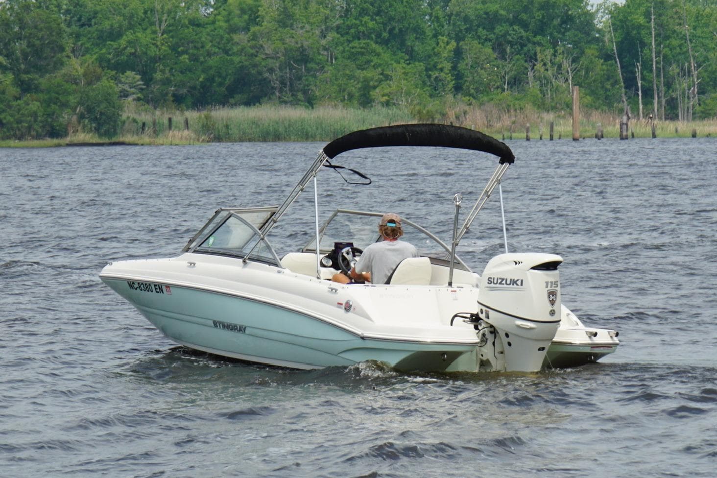 2020 Stingray 191 DC boat cruising on a lake with Suzuki outboard motor.