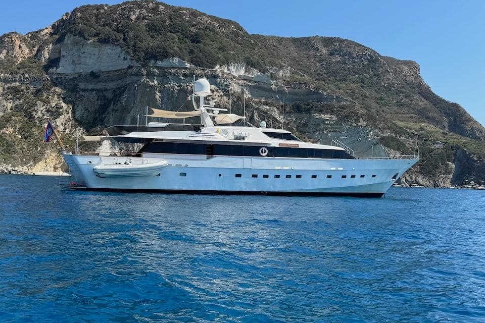 Luxury yacht W.A. Souter & Sons 34, 1984, anchored near rocky coastline.