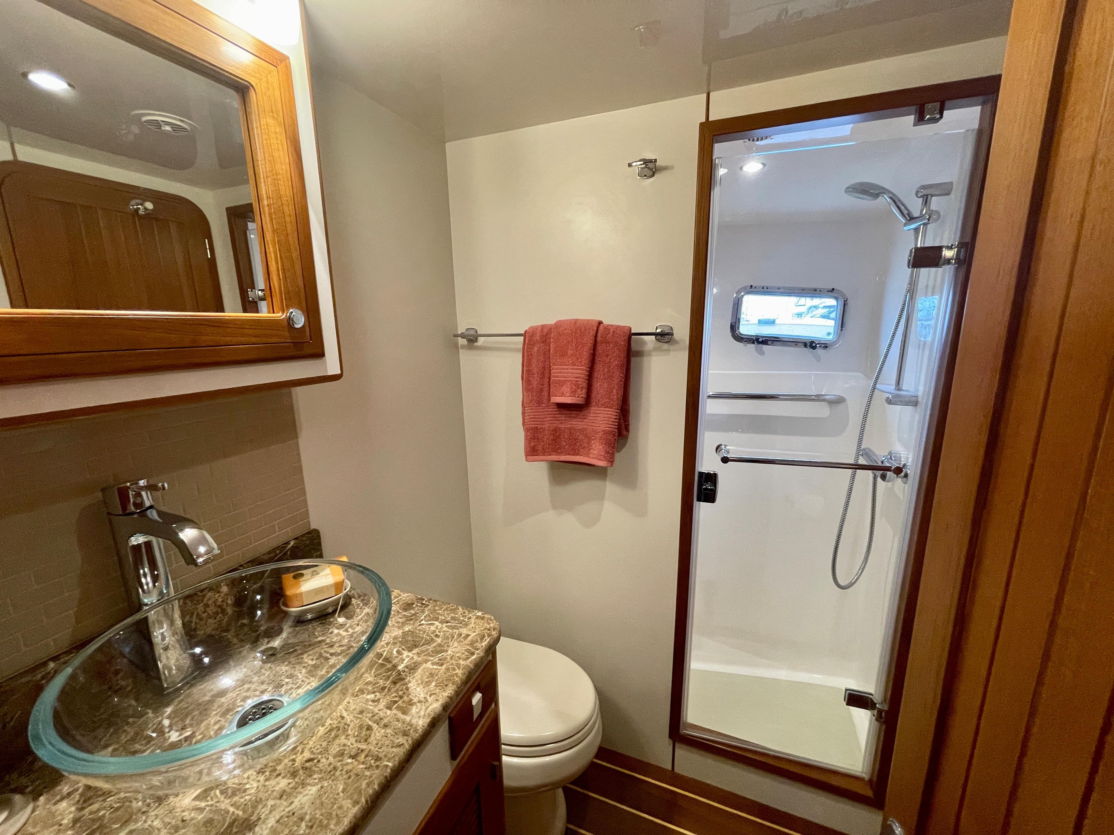 Luxurious 2017 Kadey-Krogen 58EB yacht bathroom with glass sink and shower.