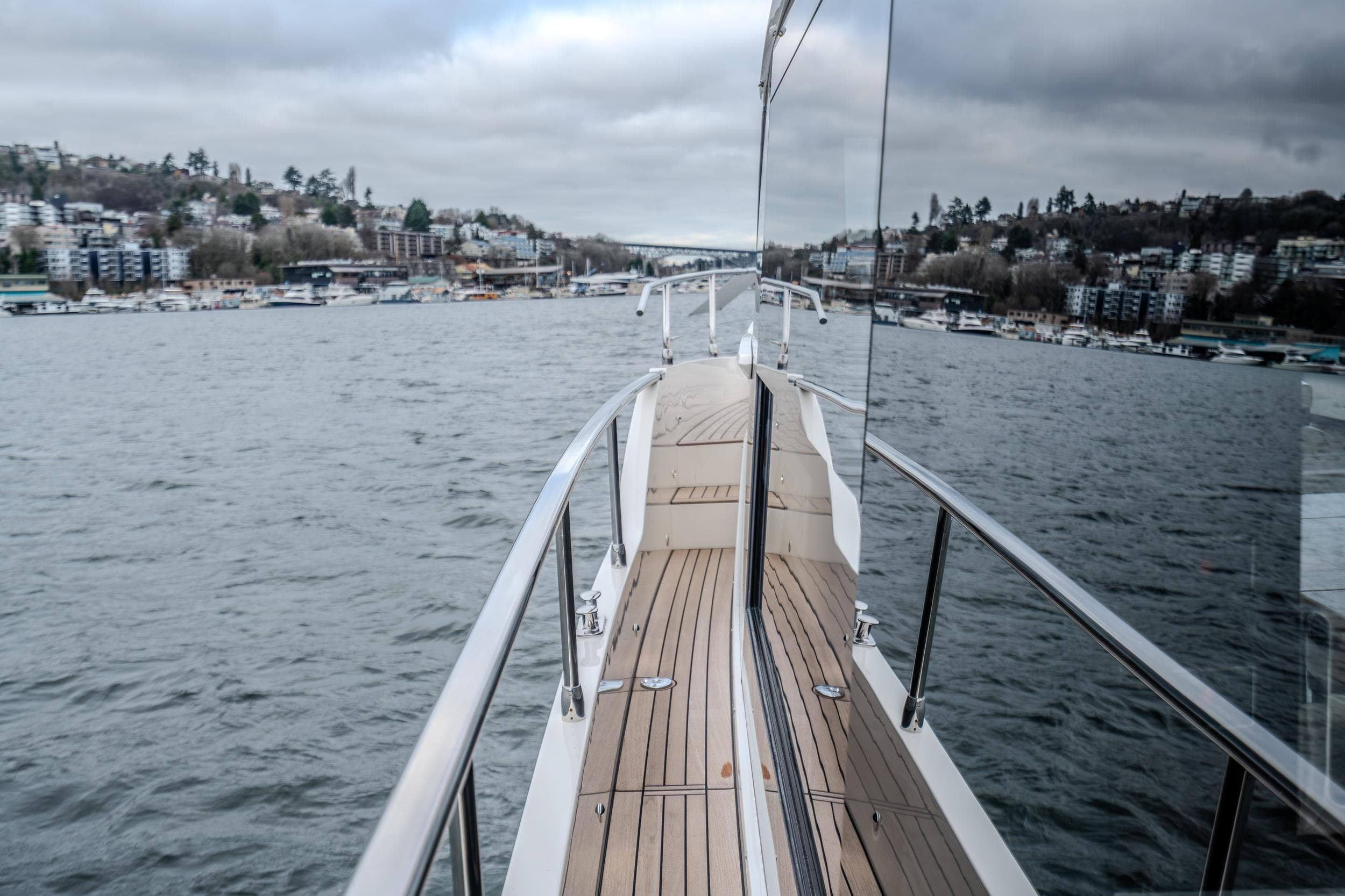 2026 Absolute 48 Coupe yacht cruising on a scenic waterway with cityscape views.