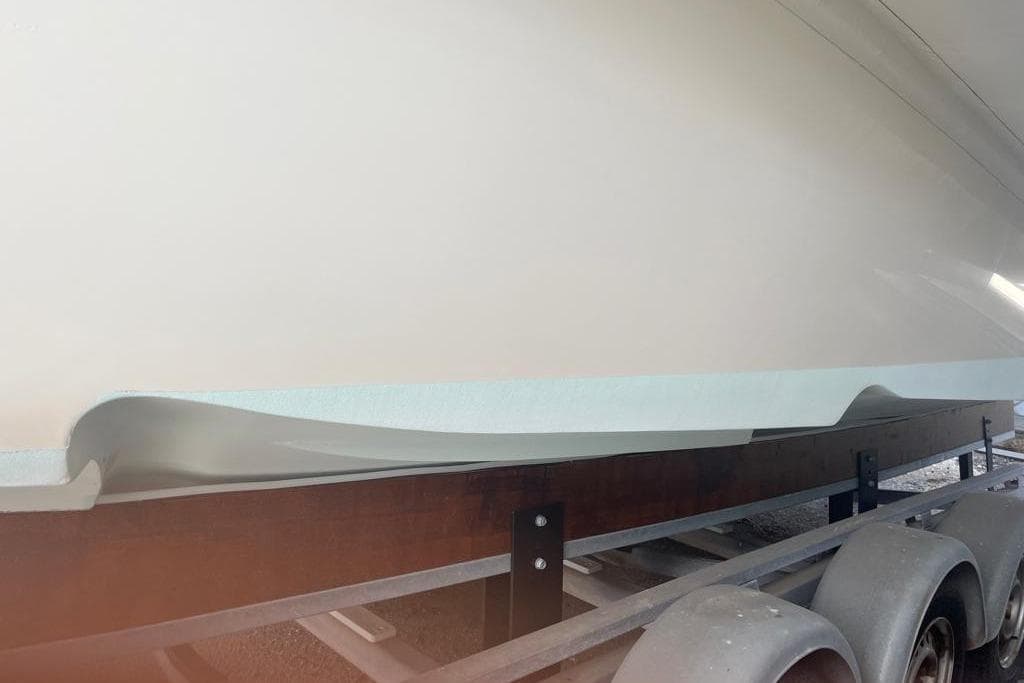 Side view of a 2016 Albatro 32 boat hull on a trailer.
