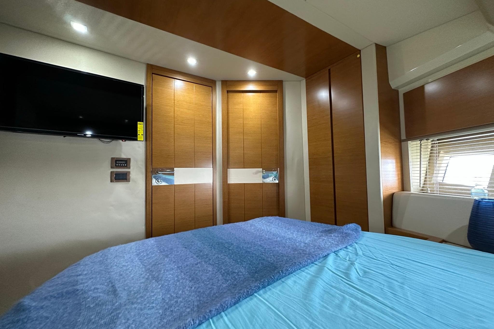 Interior of 2013 Azimut Fly 53 yacht bedroom with modern wood paneling and TV.